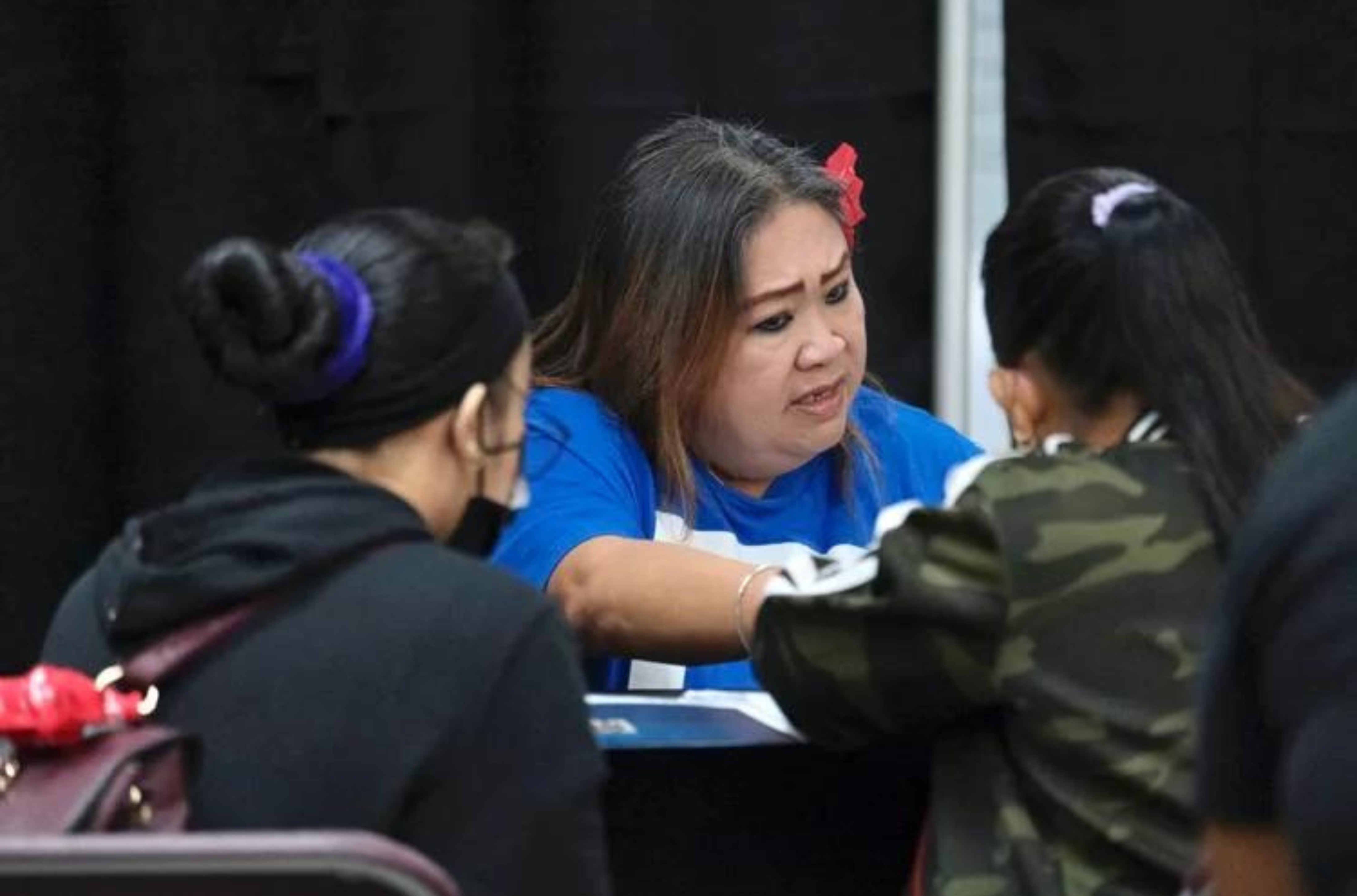 Realtor Clariza Samaniego of Today’s Realty assists disaster victims of Typhoon Mawar with their applications for the Guam Realtors Housing Relief Assistance Program at the Micronesia Mall in Dededo on July 22, 2023. 