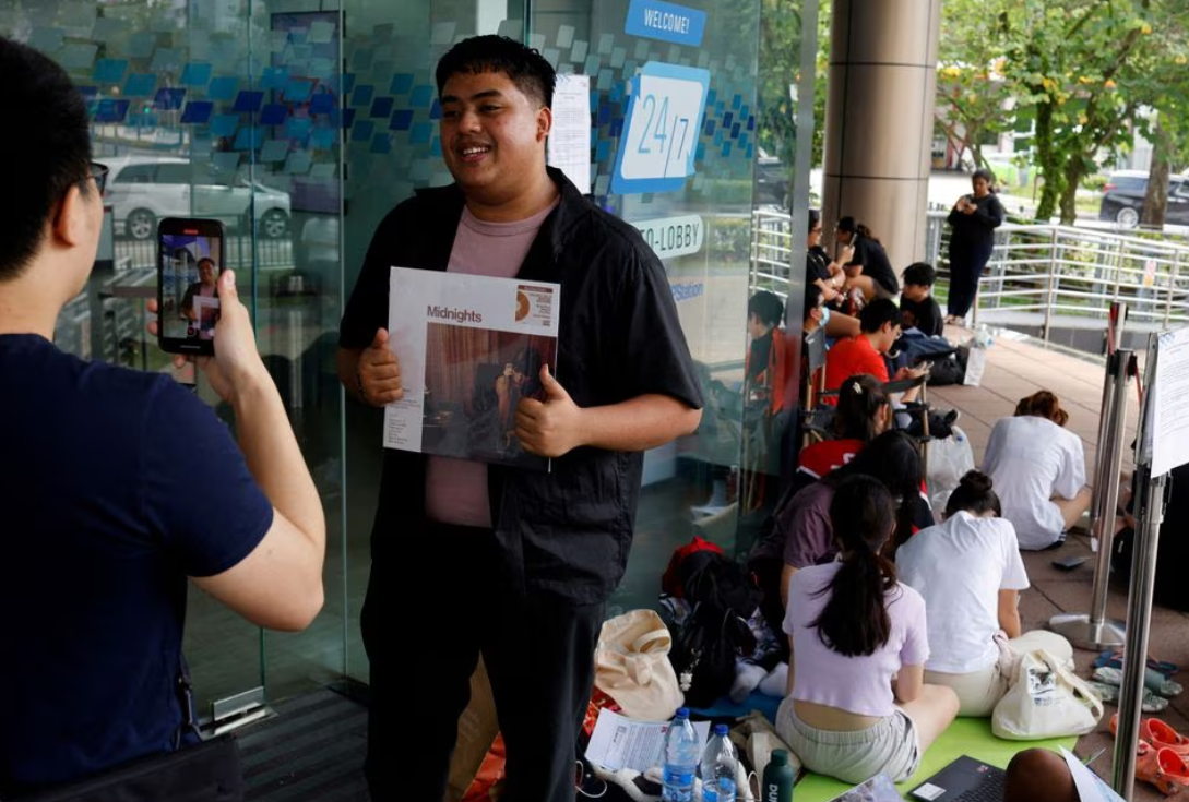 Qayyum Lukman, 25, full-time national serviceman, poses with a Taylor Swift vinyl album, as he waits first in line to buy Taylor Swift concert tickets, at a post office in Singapore, July 7, 2023.