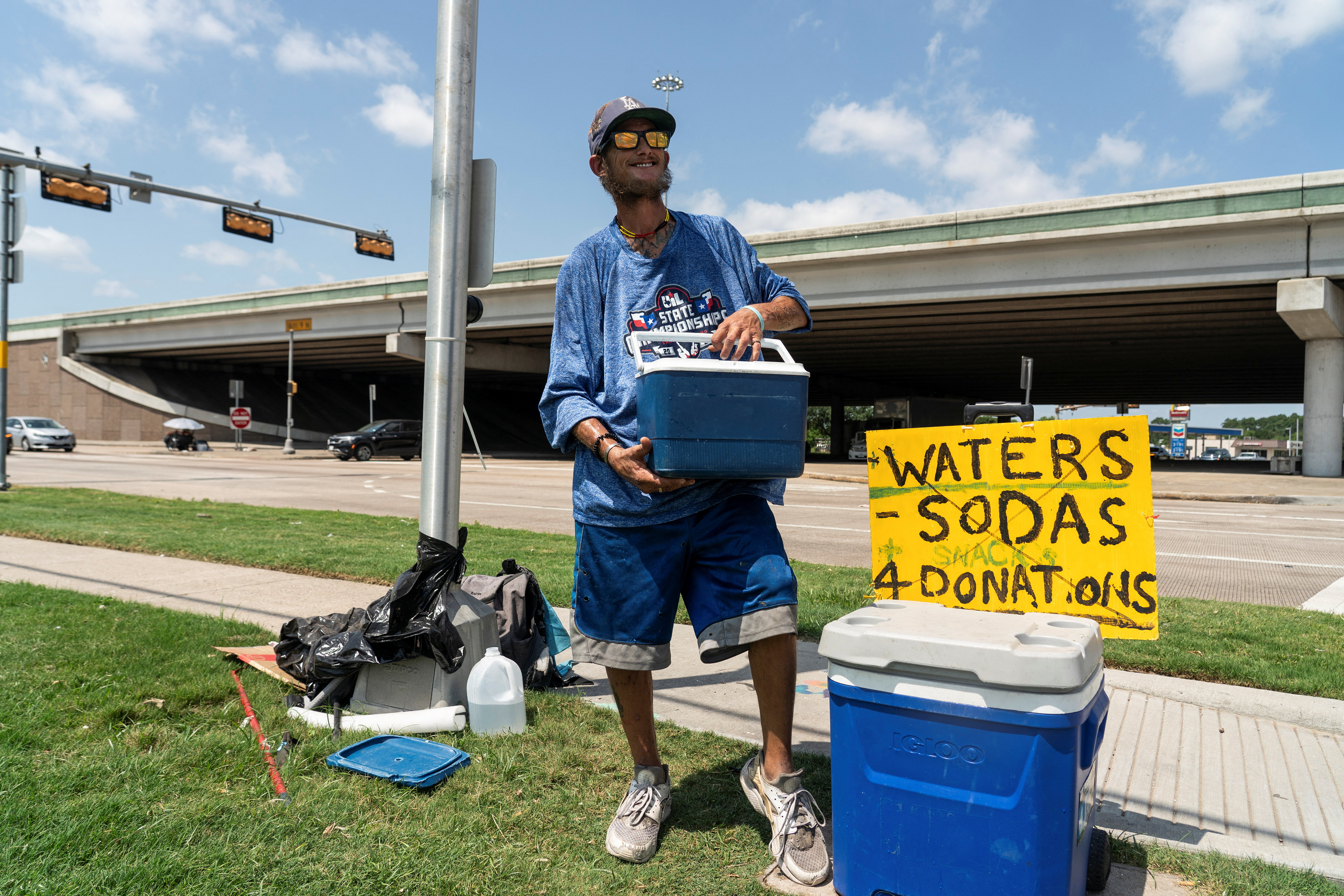 Marc Newman sells cold water to drivers during hot weather in Houston, Texas, U.S. June 28, 2023. REUTERS/Go Nakamura