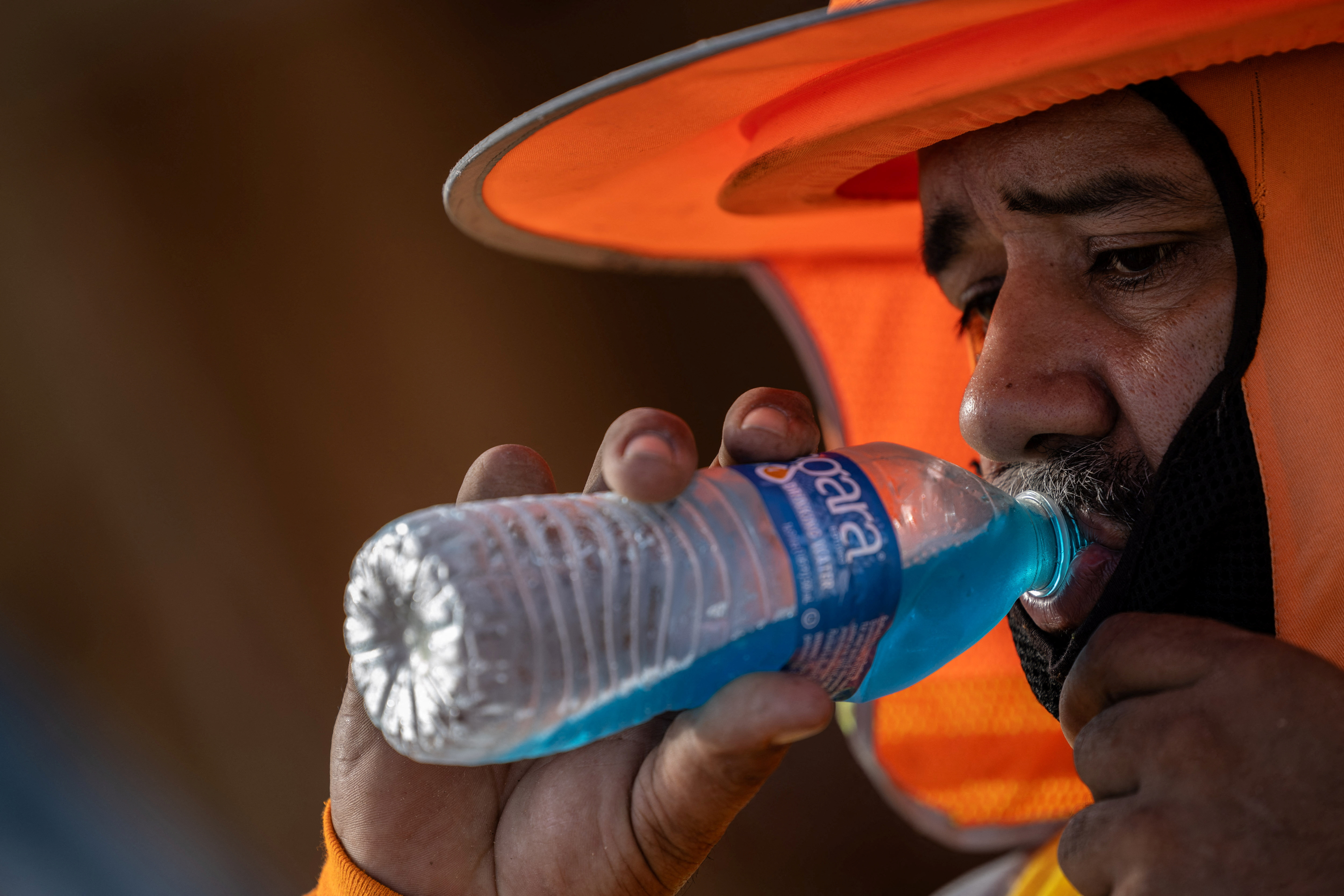 A construction worker drinks a cold beverage during a heat wave where temperatures rise over 110 degrees Fahrenheit for 27 consecutive days, in Scottsdale, at the Phoenix metro area, Arizona, U.S., July 28, 2023. REUTERS/Carlos Barria