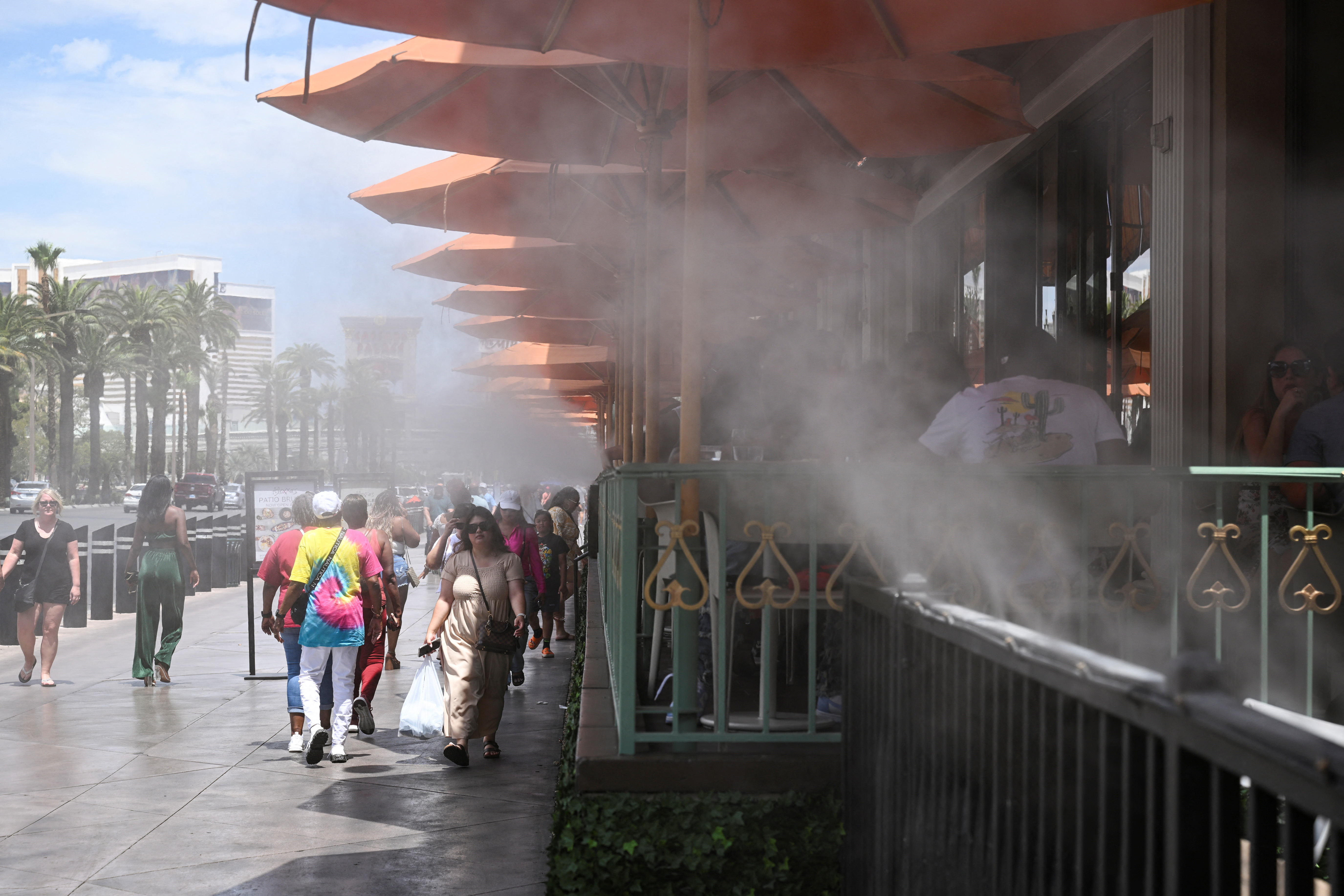 Pedestrians pass misters along the Strip during an excessive heat warning in Las Vegas, Nevada, U.S. July 17, 2023. REUTERS/Bridget Bennett/File Photo