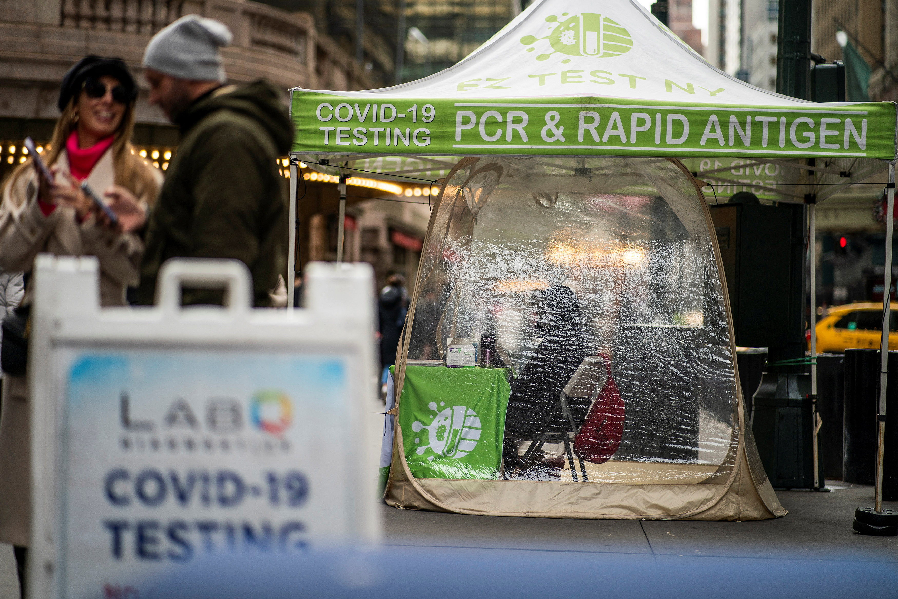 People walk next to coronavirus disease (COVID-19) testing sites in New York City, New York, U.S., December 12, 2022. REUTERS/Eduardo Munoz