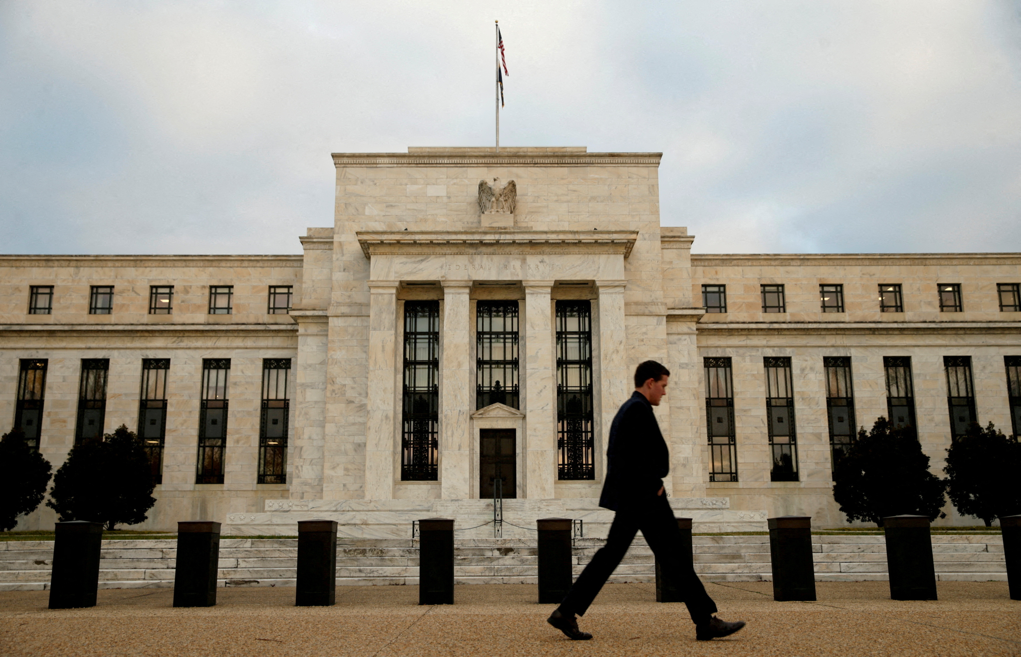 A man walks past the Federal Reserve in Washington, December 16, 2015. REUTERS/Kevin Lamarque/File Photo