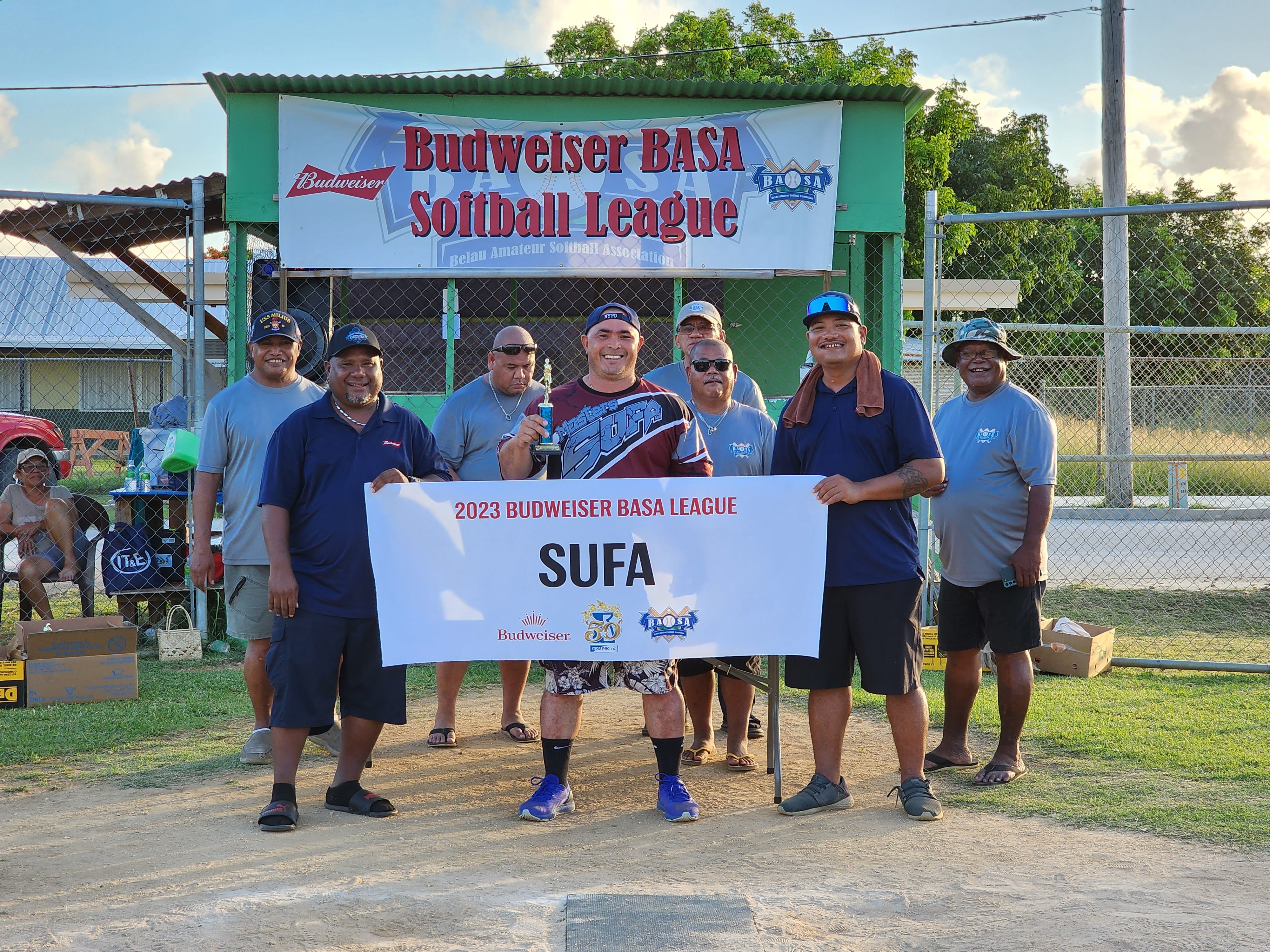 Audie Maratita holds the homerun champion trophy as he poses for a photo with the 2023 Budweiser Belau Amateur Softball Association Softball League officials during the awards ceremony at the Dandan baseball field on Sunday.
