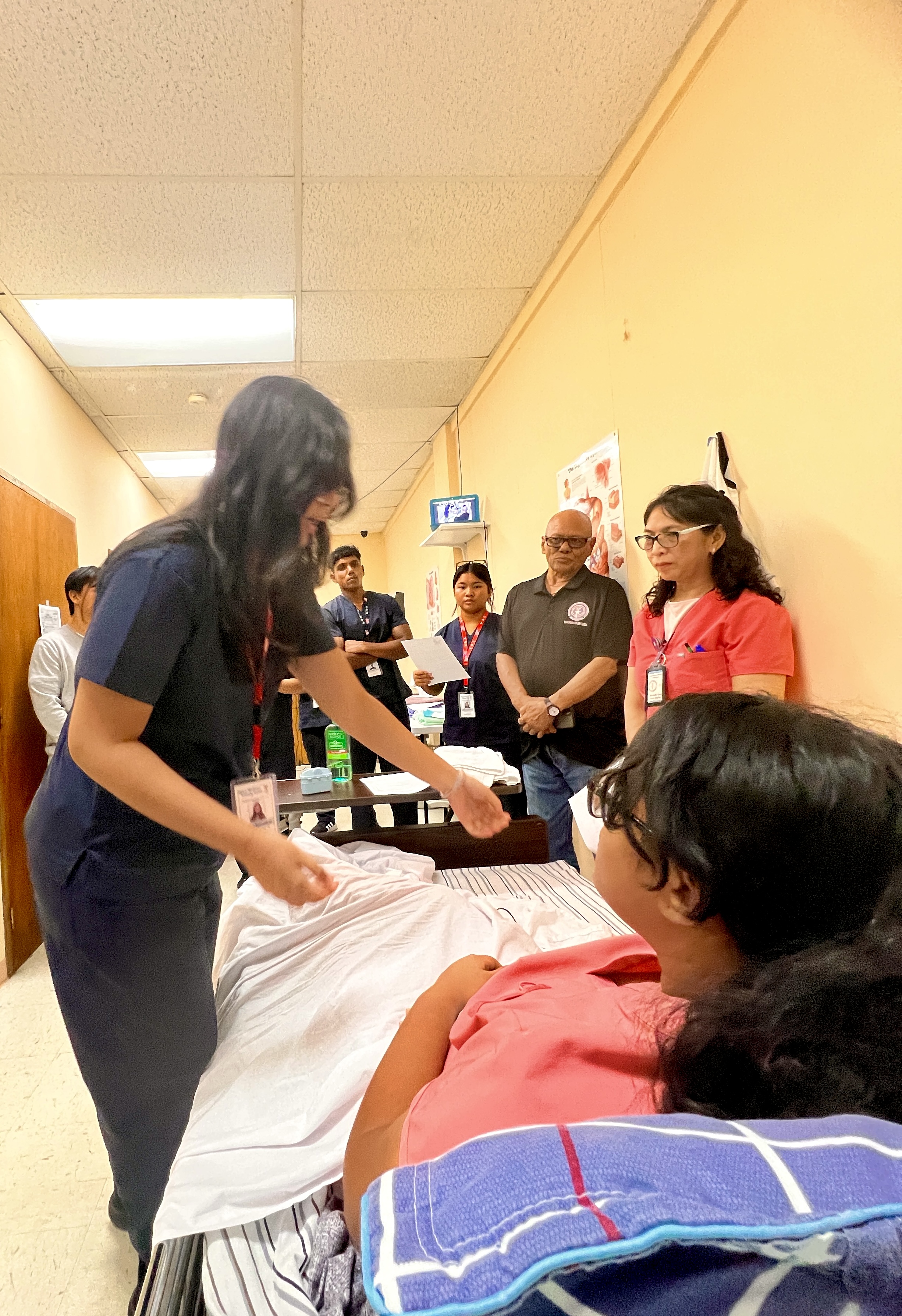 Board of Education Vice Chairman Herman Atalig, standing second right, watches a Certified Nursing Assistant Program training session at the Guam Marianas Training Center in Chalan Laulau on Middle Road.