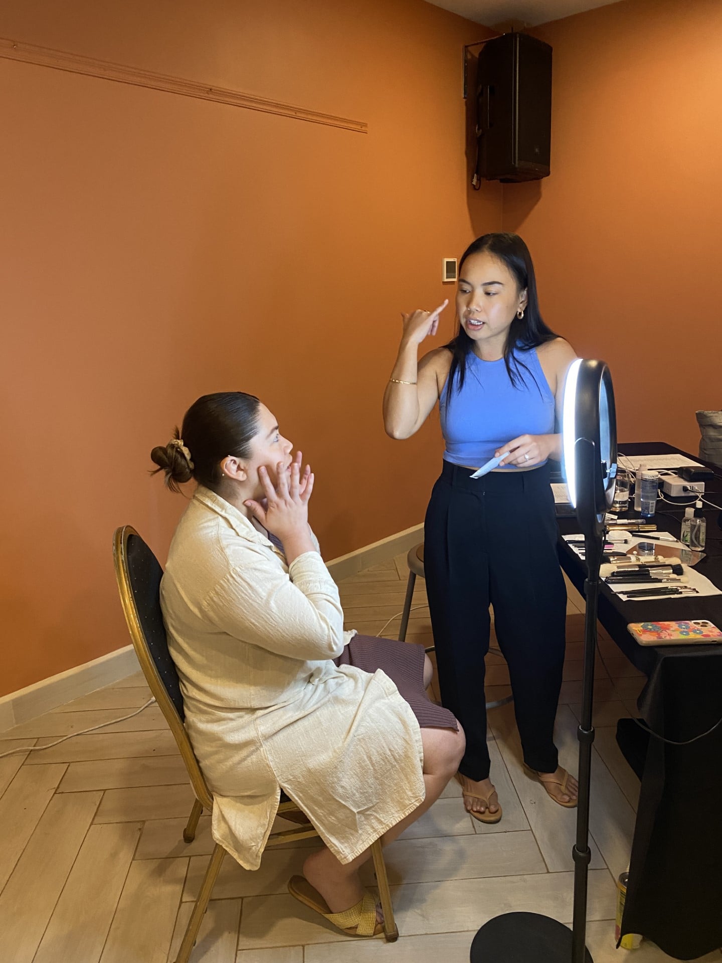 Kristin Hofschneider, right, discusses make-up with a client during a live demonstration at Crowne Plaza for the launch of NMTech’s cosmetology program.