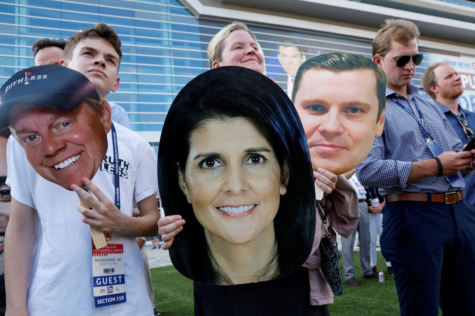 An attendee holds a picture of Republican presidential candidate and former U.S. Ambassador to the United Nations Nikki Haley — sandwiched between pictures of podcaster John Ashbrook and Michael Duncan — as people arrive at the debate hall to watch the Republican U.S. presidential candidates in their first primary debate of the 2024 campaign in Milwaukee, Wisconsin, U.S. August 23, 2023. REUTERS/Jonathan Ernst