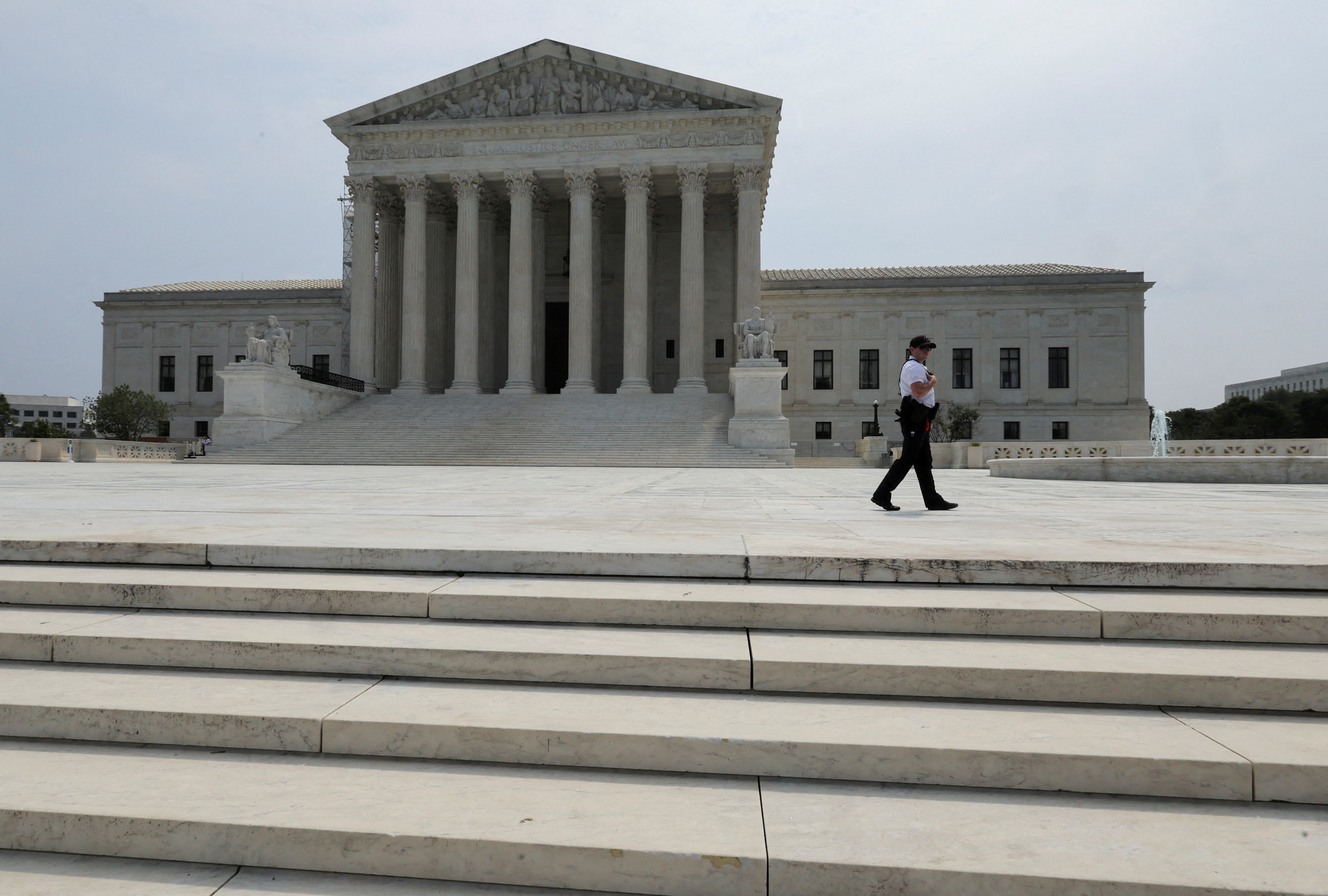 A police officer patrols outside the U.S. Supreme Court in Washington, U.S. June 30, 2023.  REUTERS/Jim Bourg/File Photo