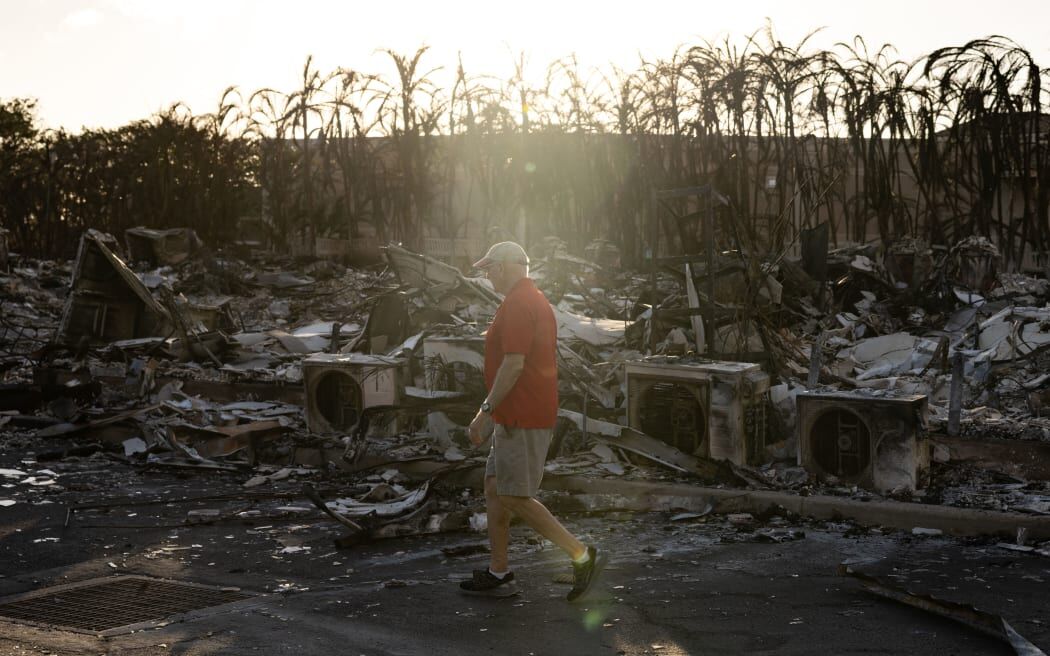 A resident looks around a charred apartment complex in the aftermath of a wildfire in Lahaina, western Maui, Hawaii on 12 August