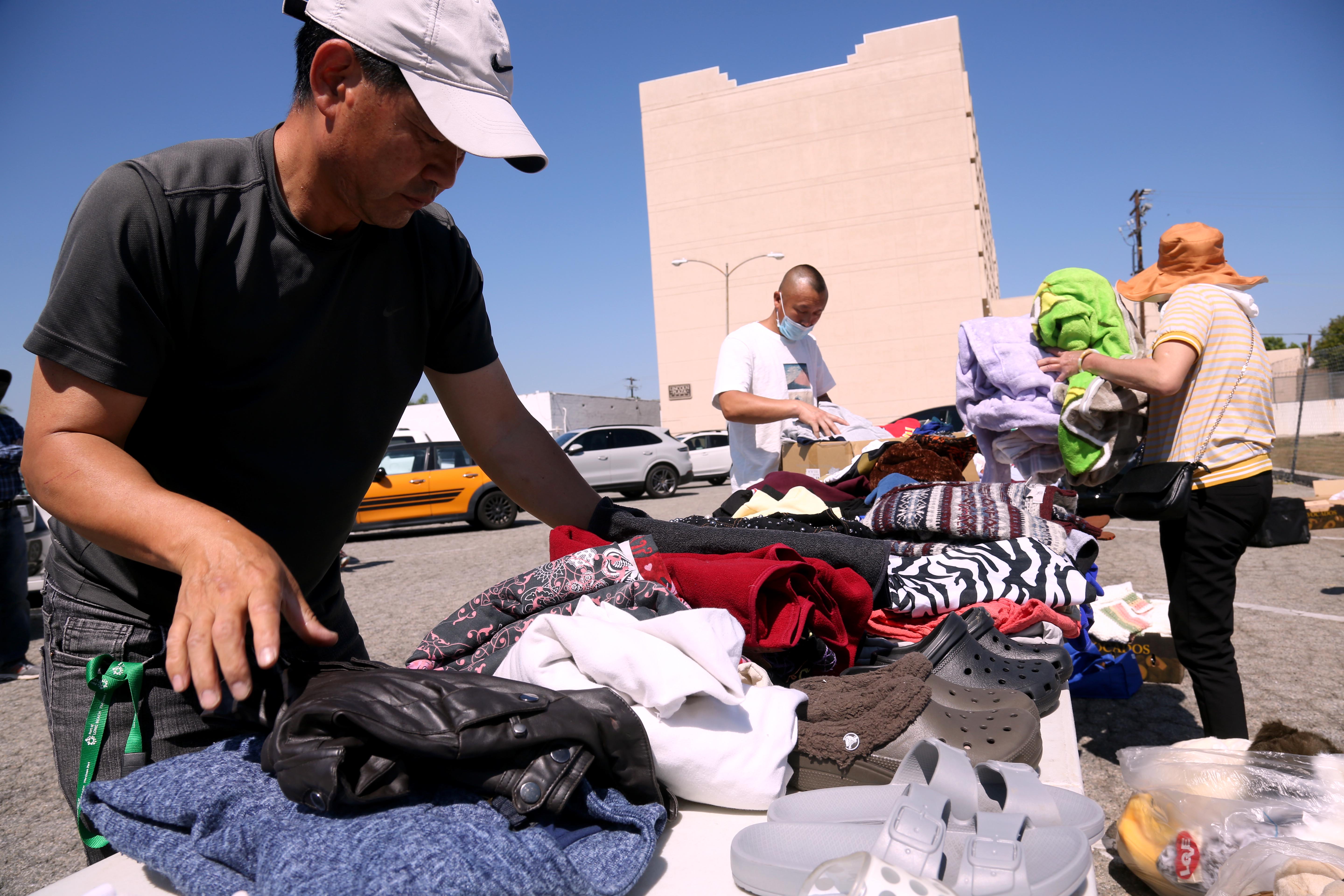 David Lu, left, and other volunteers set out clothing, toys and other donated items for Chinese migrants in a parking lot in Monterey Park in June. (Genaro MolinaLos Angeles Times/TNS) David Lu, left, and other volunteers set out clothing, toys and other donated items for Chinese migrants in a parking lot in Monterey Park in June. (Genaro MolinaLos Angeles Times/TNS)