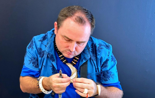 A craftsman makes jewelry from shells on July 20, 2023, at The Marianas Experience, a free interactive cultural experience open to the public on Tuesdays, Thursdays, and Saturdays at T Galleria in Garapan, Saipan.