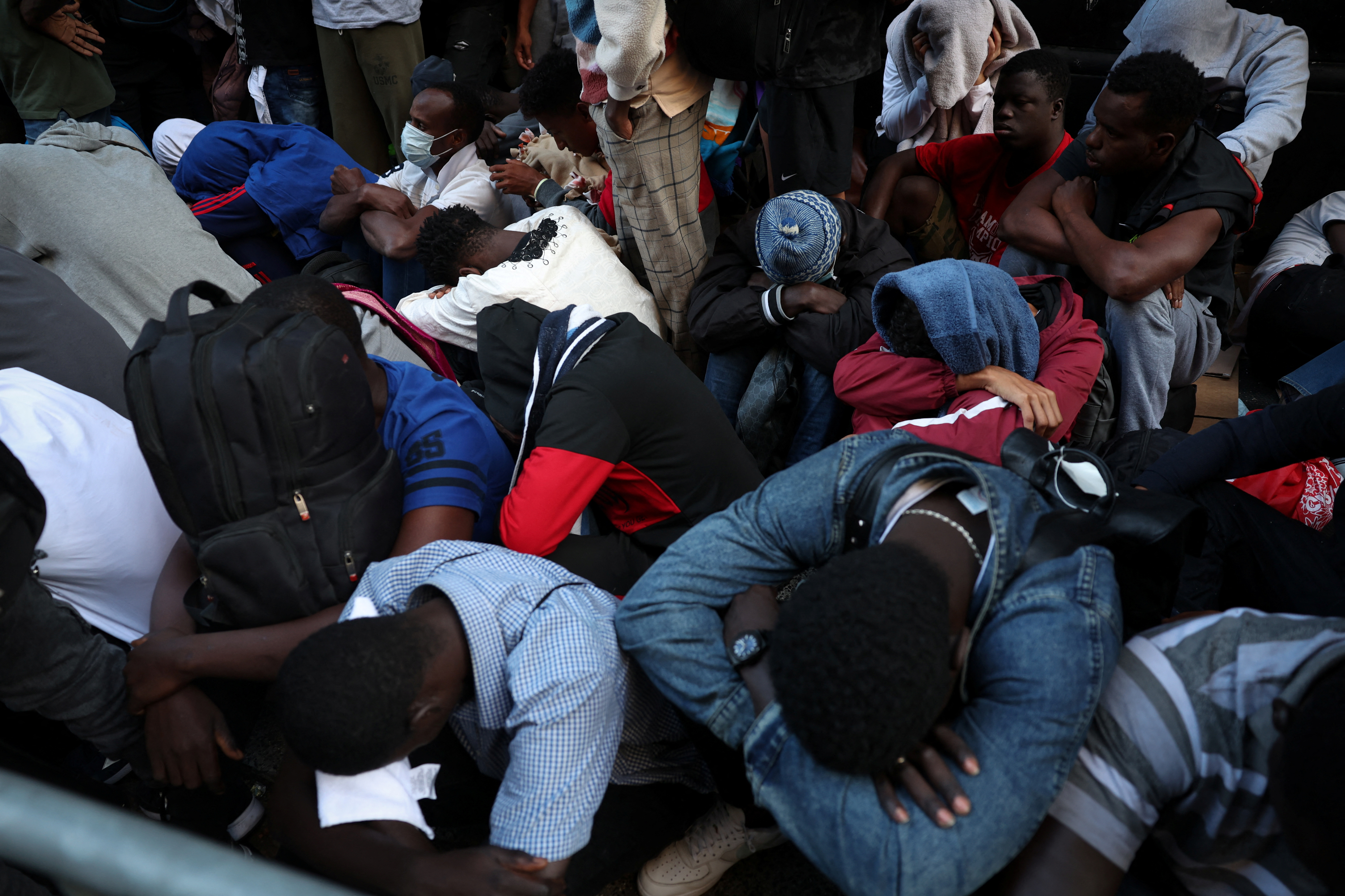 Recently arrived migrants to New York City wait on the sidewalk outside of the Roosevelt Hotel in midtown, Manhattan, where a temporary reception center has been established in New York City, New York, U.S., August 1, 2023. REUTERS/Mike Segar