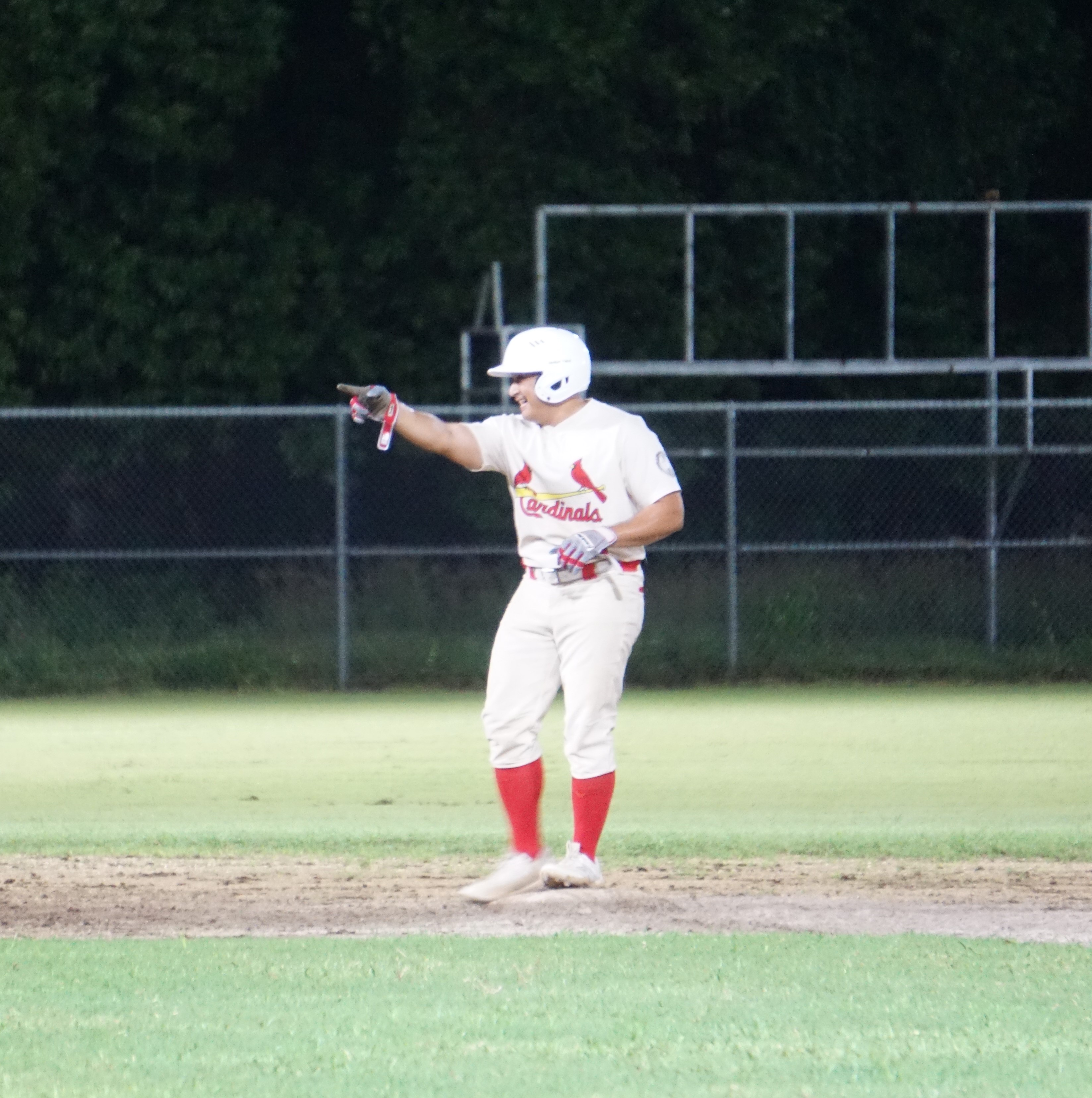 The Cardinals' Nokki Saralu acknowledges his teammate after both safely advanced during a game against the Junior Nationals in the 2023 Tan Holdings Saipan Baseball League at the Francisco "Tan Ko" Palacios Baseball Field.