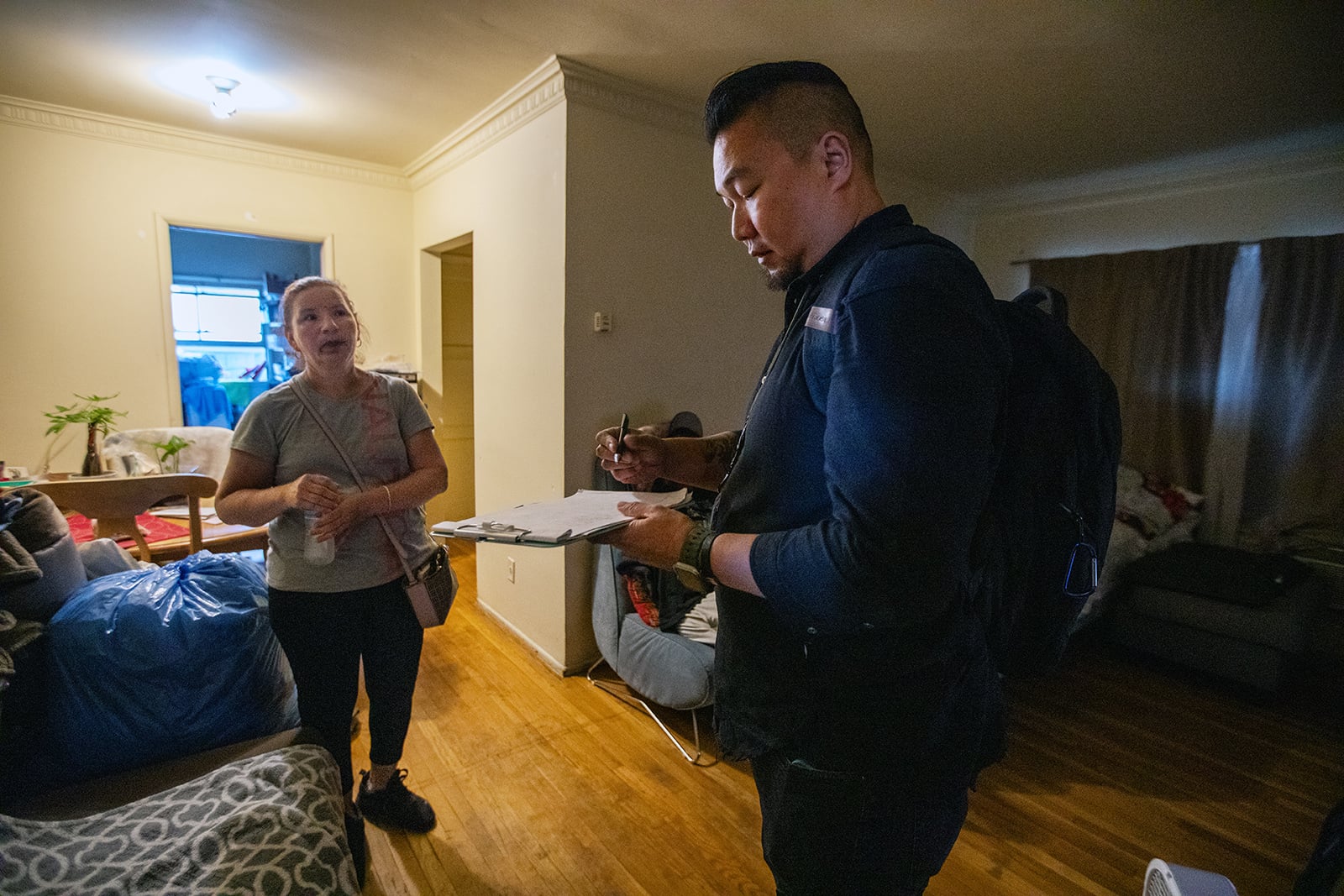 Delcia Calderon, left, speaks with Luwin Kwan, a licensed mental health professional, in her Los Angeles apartment. A mobile crisis team was dispatched to help her adult son, who appeared to be in emotional distress. (Francine Orr/Los Angeles Times/TNS)