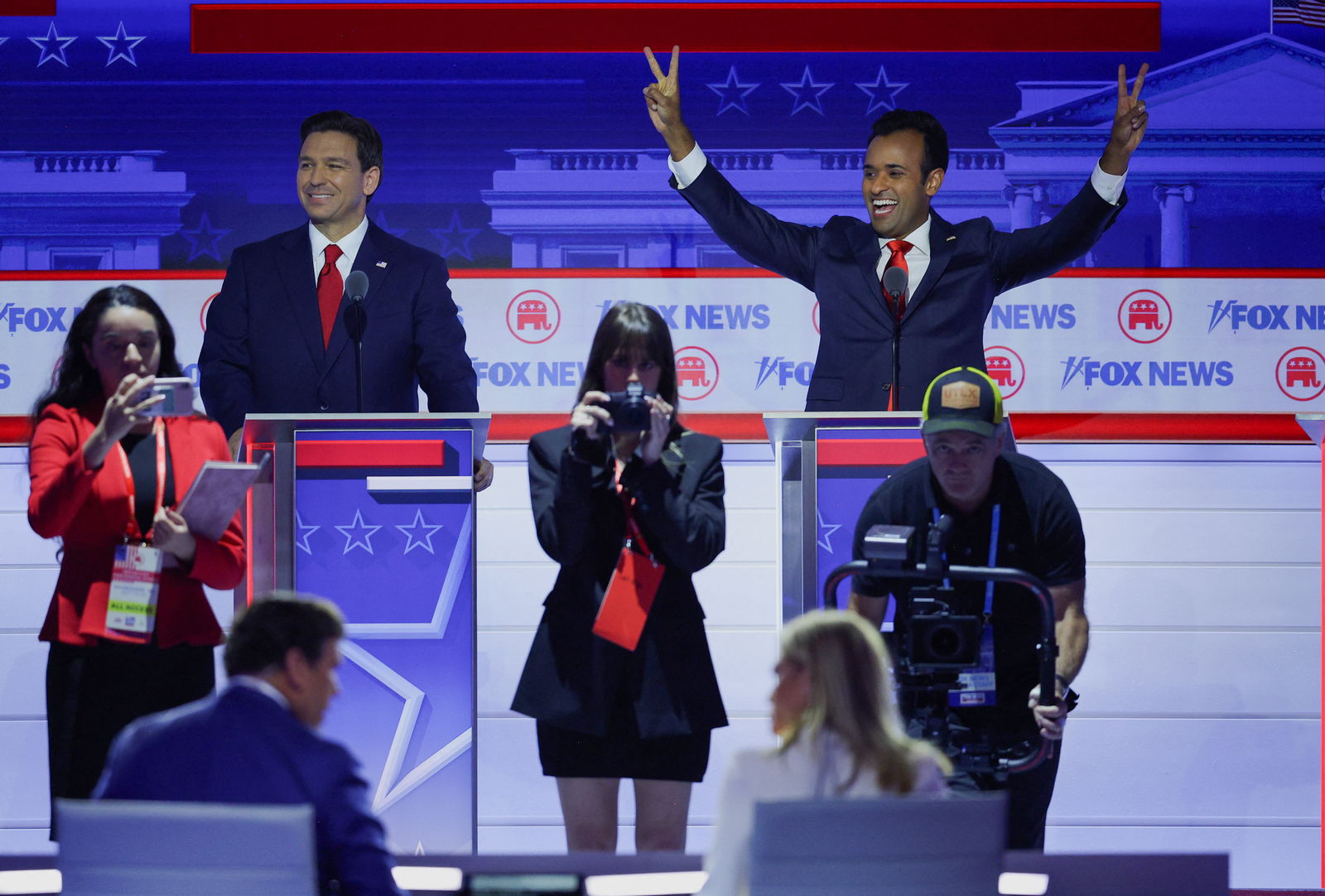 Florida Governor Ron DeSantis stands behind his podium as former biotech executive Vivek Ramaswamy gestures at the first Republican candidates' debate of the 2024 U.S. presidential campaign in Milwaukee, Wisconsin, U.S. August 23, 2023. REUTERS/Brian Snyder