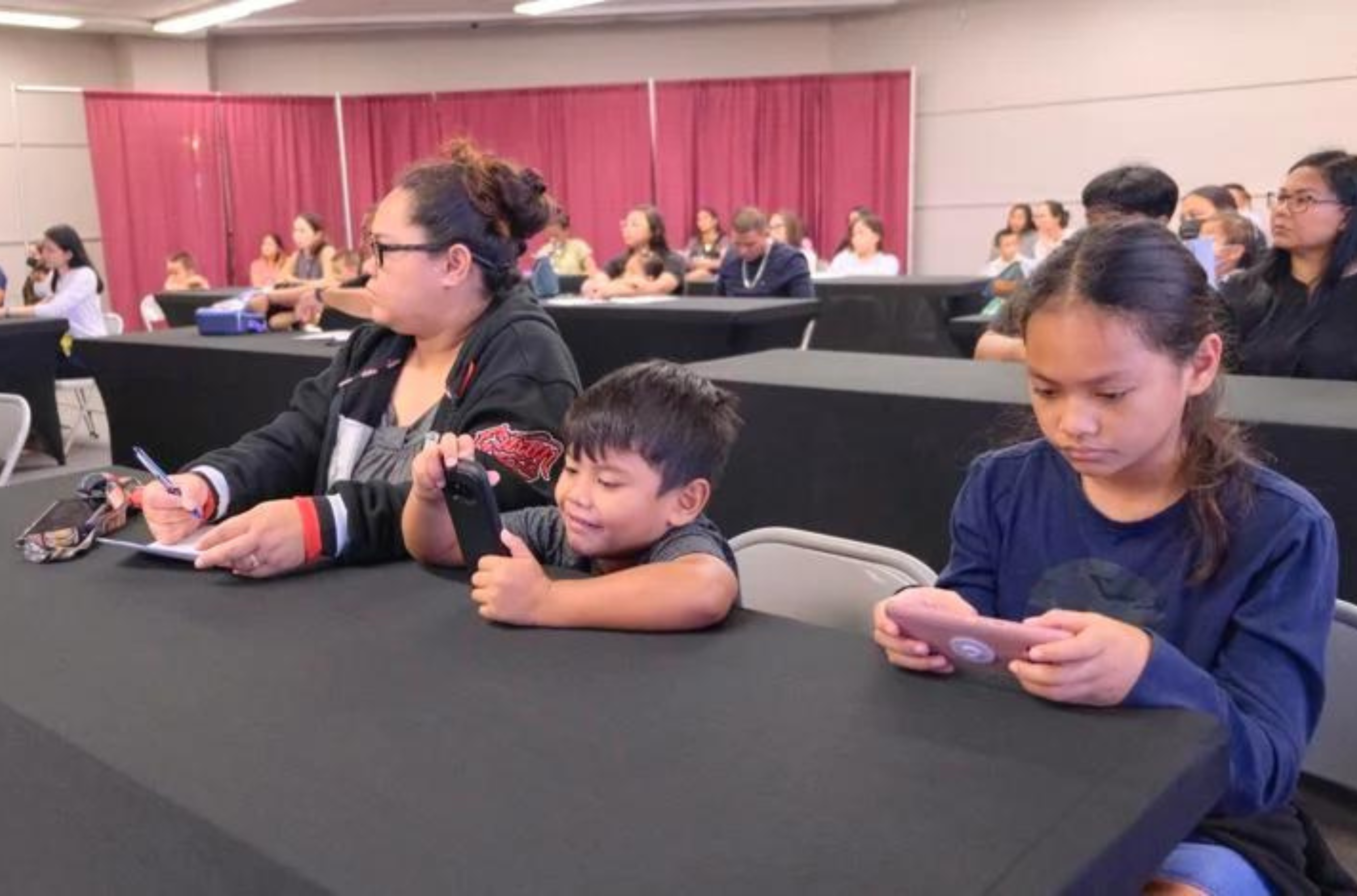 Ashley Pascua, left, attends a Liguan Elementary School orientation with her children Vance Toves, 5, center, and Alessandra Toves, 9, at the Micronesia Mall in Dededo on Tuesday, Aug. 15, 2023. 
