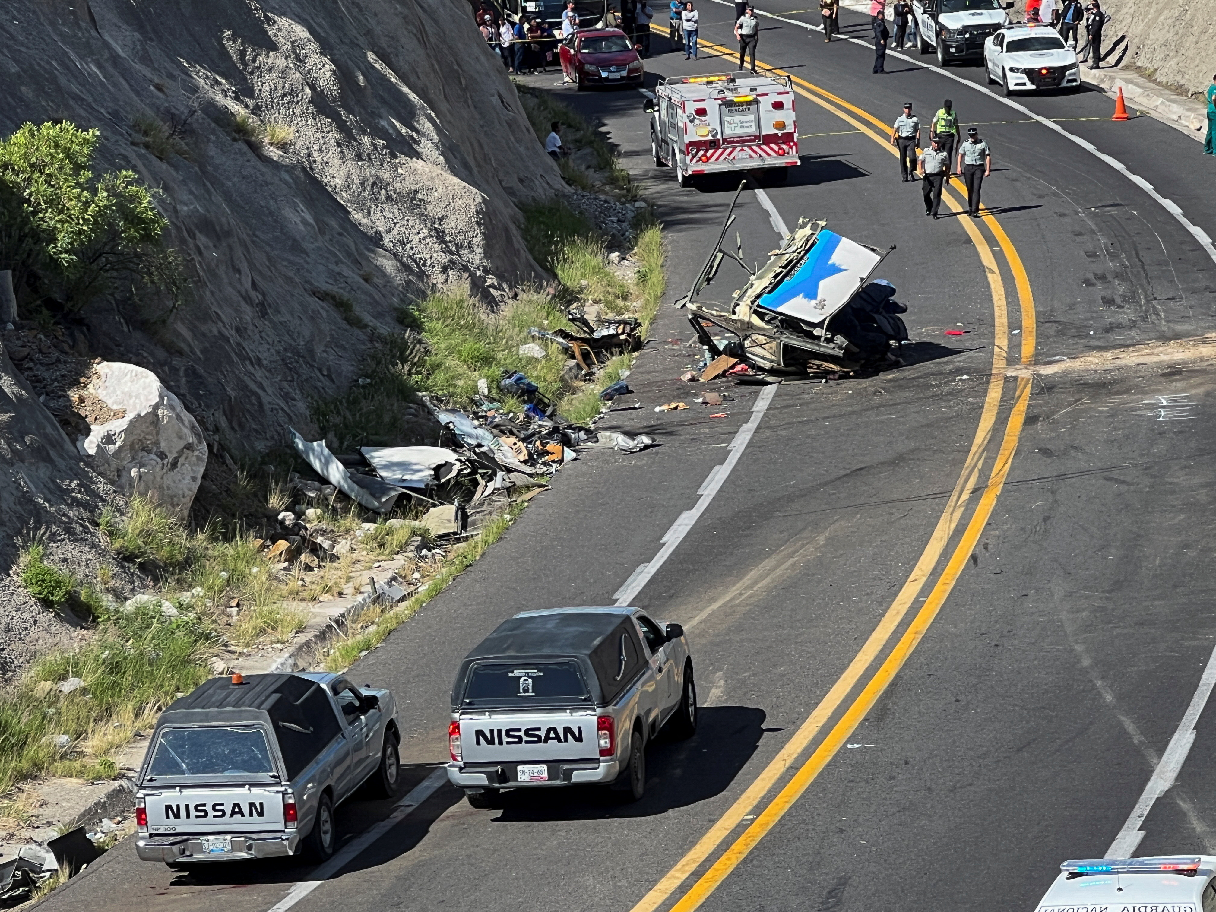 Members of the National Guard walk near the wreckage of a bus at the area of a road accident, which left over a dozen migrants dead, in Tepelmeme Villa de Morelos, in Oaxaca state, Mexico August 22, 2023. REUTERS/Jose de Jesus Cortes