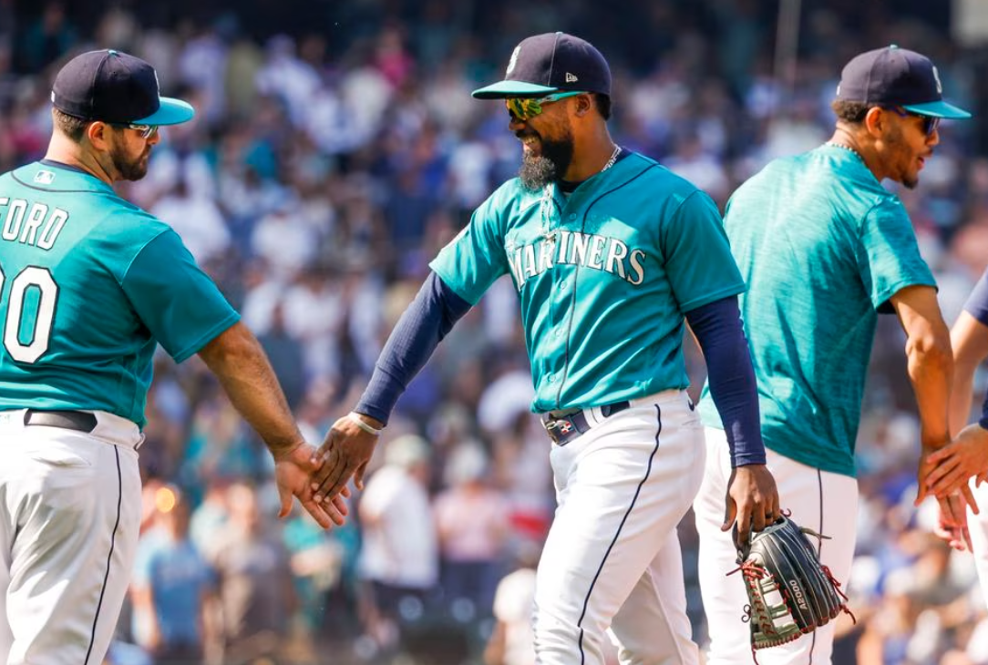 Seattle Mariners designated hitter Mike Ford (20) shakes hands with right fielder Teoscar Hernandez (35, second from right) following a 15-2 victory against the Kansas City Royals at T-Mobile Park in Seattle, Washington, Aug. 28, 2023.