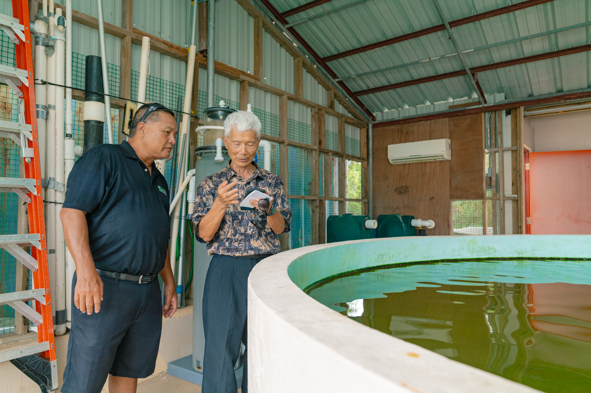 Executive Director for the Center for Tropical and Subtropical Aquaculture Dr. Cheng Sheng Lee, right, discusses his findings with NMC-CREES A&NR Program Leader Michael Ogo at the NMC-CREES Aquaculture and Natural Resources Program Center.