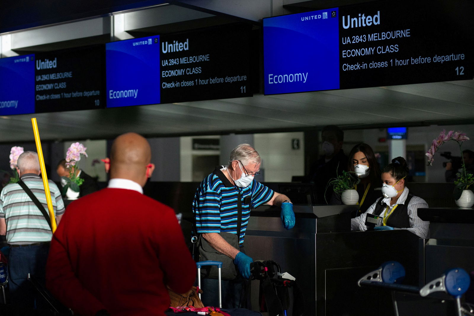 Australian citizens, who were aboard the MS Zaandam and Coral Princess cruises, now cleared to fly after quarantining, wait in line to receive their boarding passes for a specially chartered United Airlines flight to take them home to Australia at San Francisco International Airport as efforts continue to help slow the spread of coronavirus disease (COVID-19) in San Francisco, California, U.S. April 5, 2020. REUTERS/Kate Munsch/File Photo