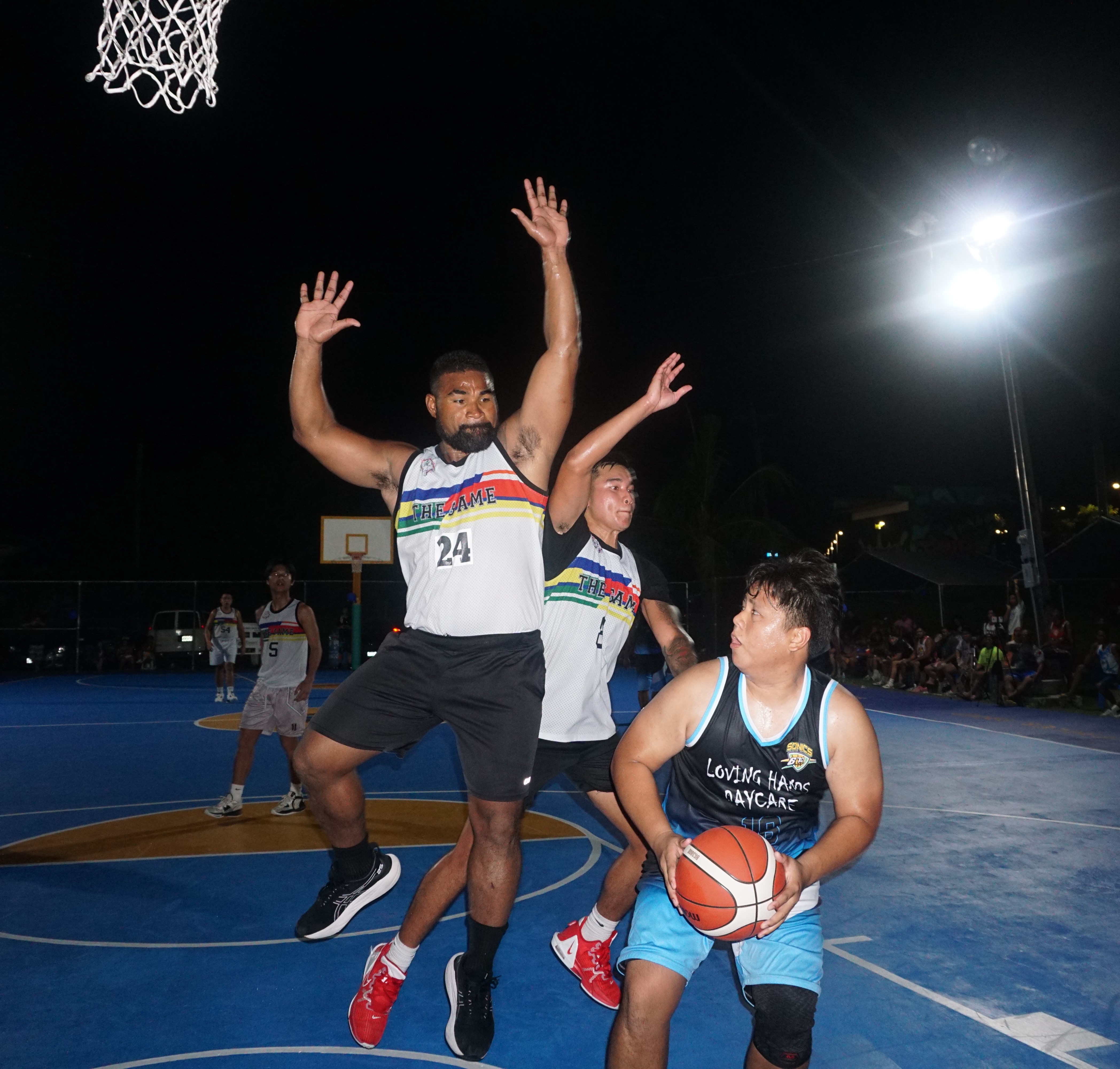 The Loving Hands' Jude Tengco baits two defenders to draw a foul during an open division game of the 2023 Saipan Magalahi Eagles Club Invitational Basketball League at the Gualo Rai basketball court.