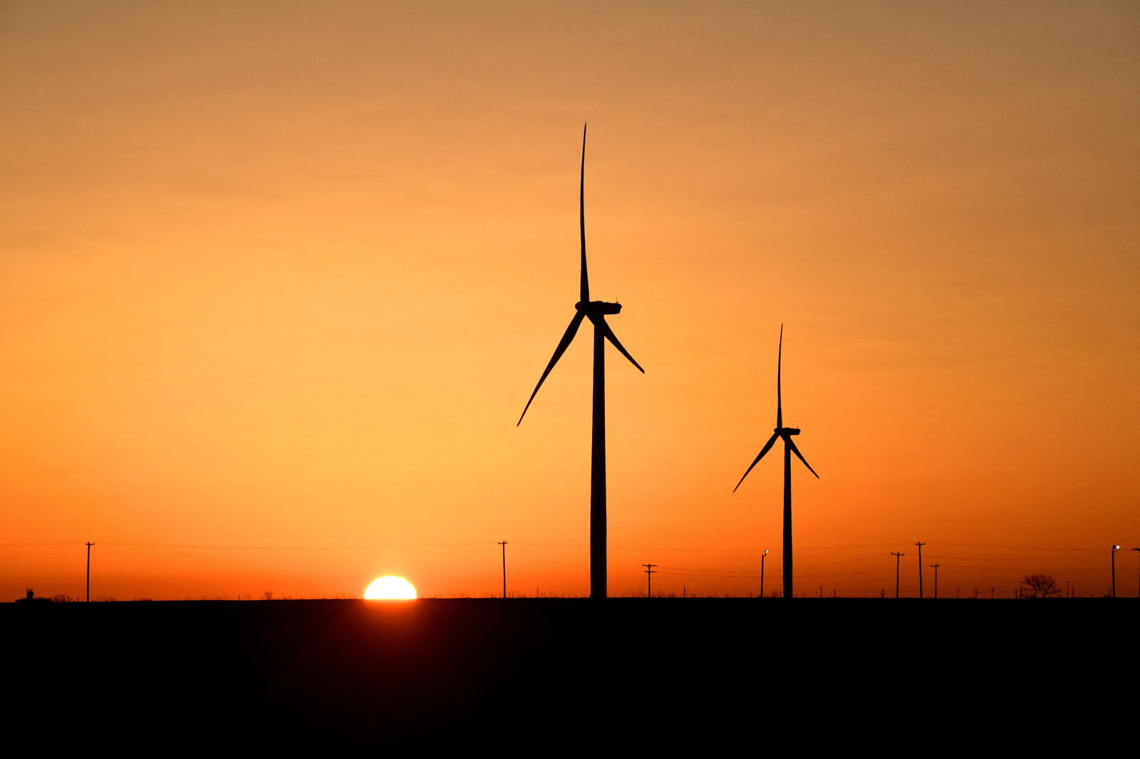 Wind turbines operate at sunrise in the Permian Basin oil and natural gas production area in Big Spring, Texas, U.S., February 12, 2019. REUTERS/Nick Oxford/File Photo
