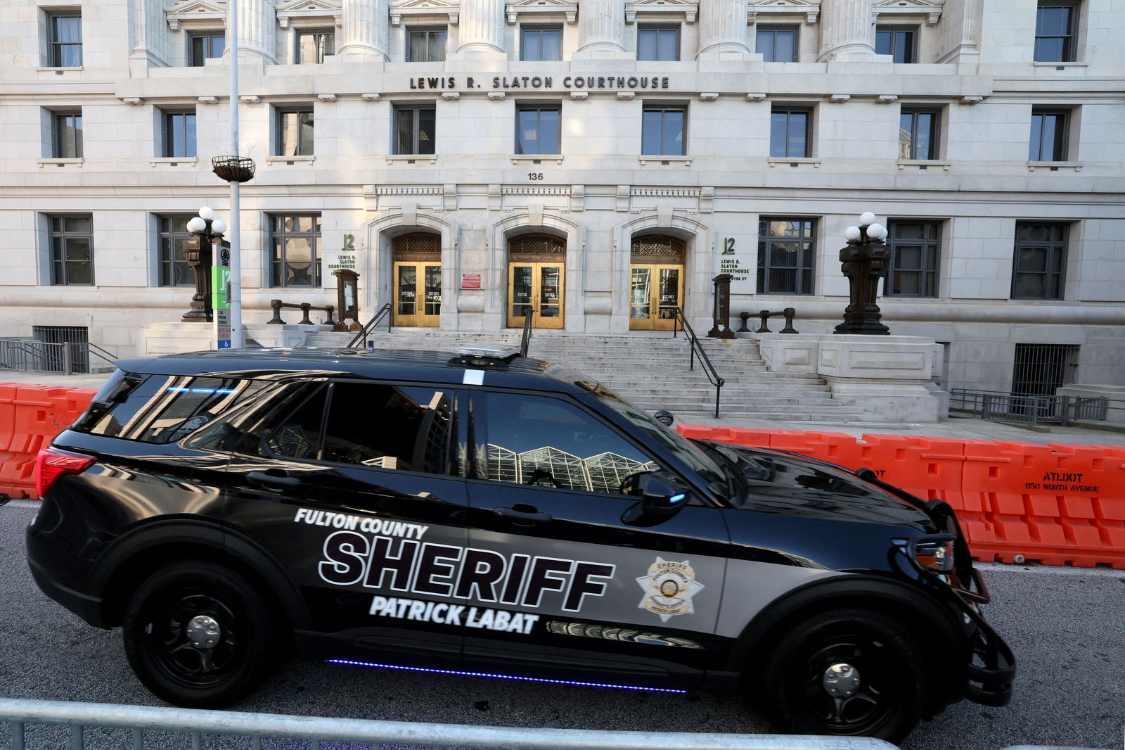 A sheriff's vehicle passes by the Lewis R. Slaton Courthouse and Superior Court of Fulton County, after a Grand Jury brought back indictments against former U.S. President Donald Trump and 18 of his allies in their attempt to overturn the state's 2020 election results, in Atlanta, Georgia, U.S. August 17, 2023. REUTERS/Brendan McDermid/File Photo