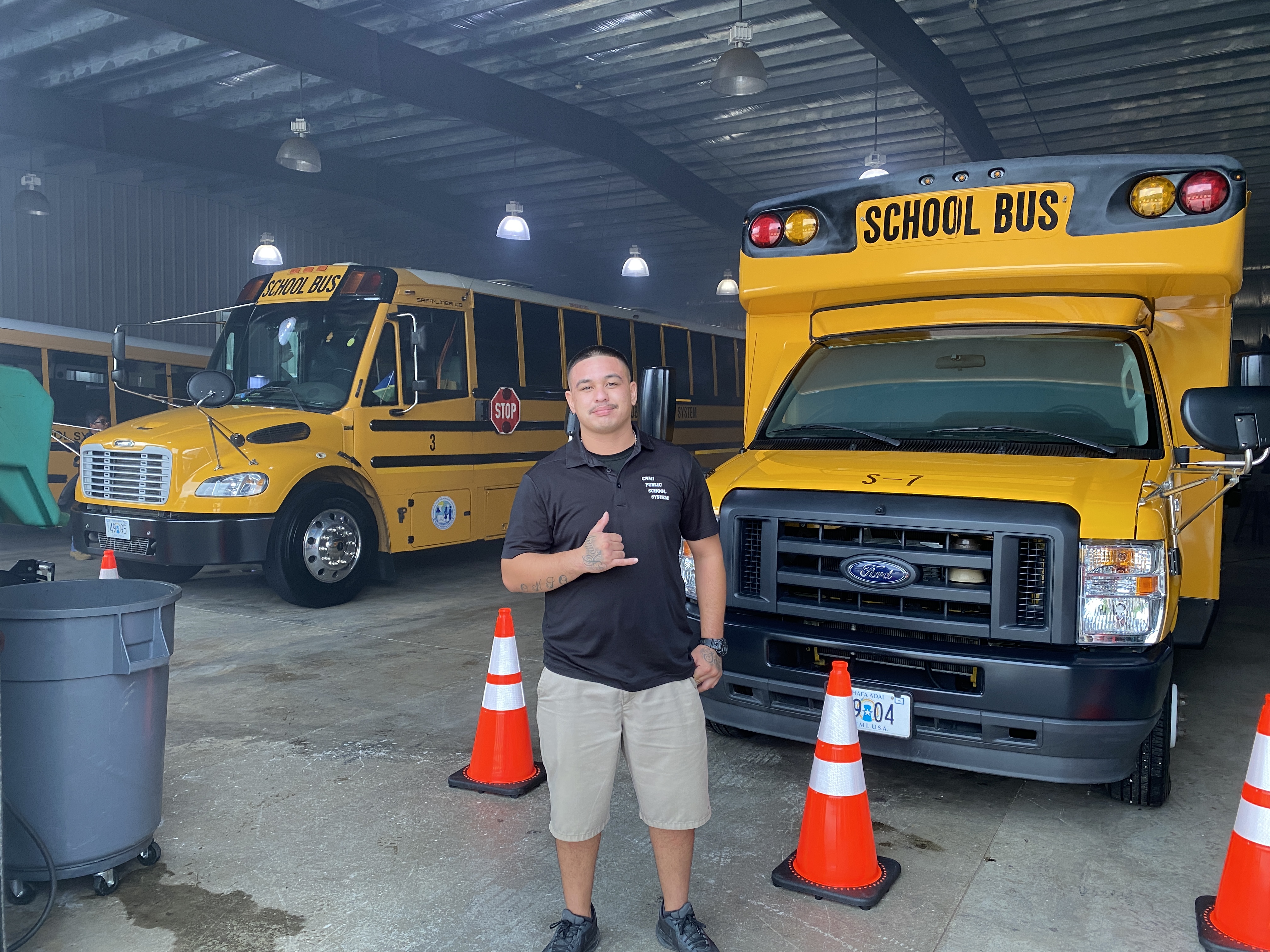 Roman Reyes stands in front of the two buses that were used during an emergency exit drill Monday. To his left, a special needs bus is seen filled with smoke. 