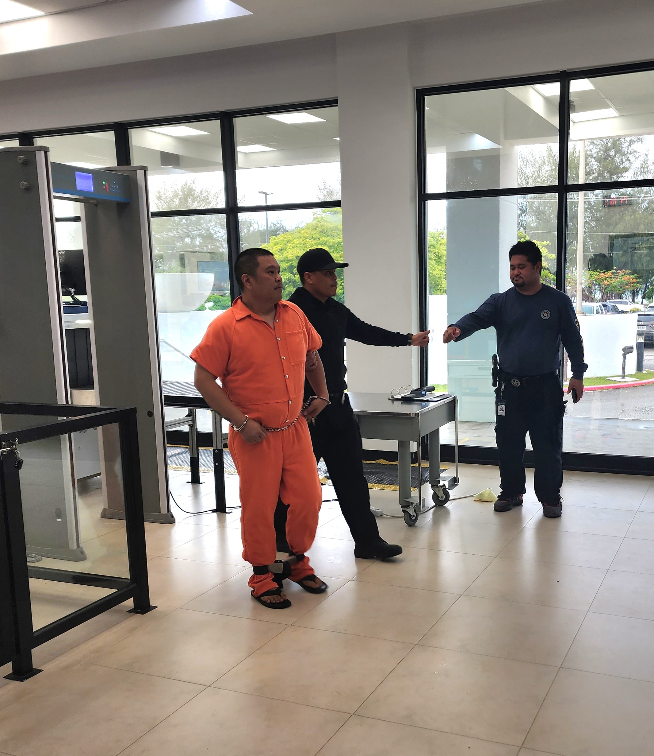 Escorted by a Corrections officer, William Hart, left, enters the Guma Hustisia for a bail hearing on Friday.