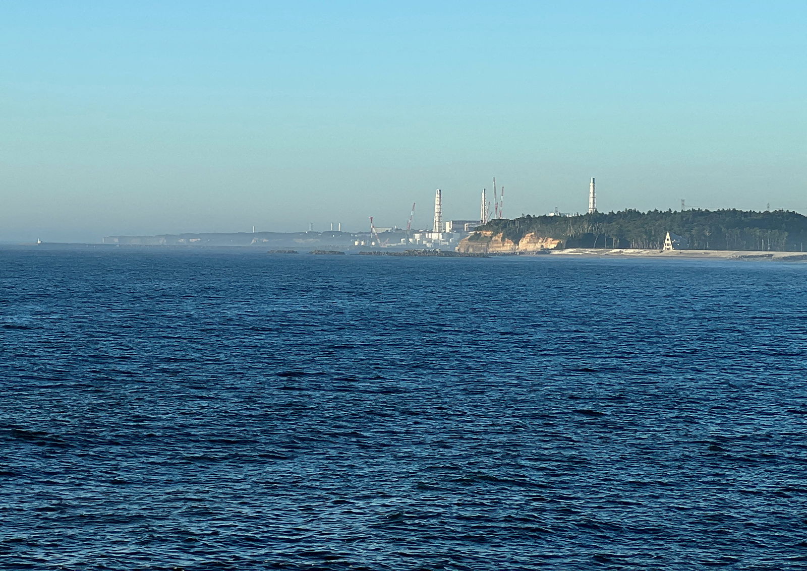 A view of the Fukushima Daiichi nuclear power plant after it started releasing treated radioactive water into the Pacific Ocean, seen from the nearby Ukedo fishing port in Namie town, Fukushima Prefecture, Japan, Aug. 25, 2023. REUTERS/Tom Bateman/File Photo