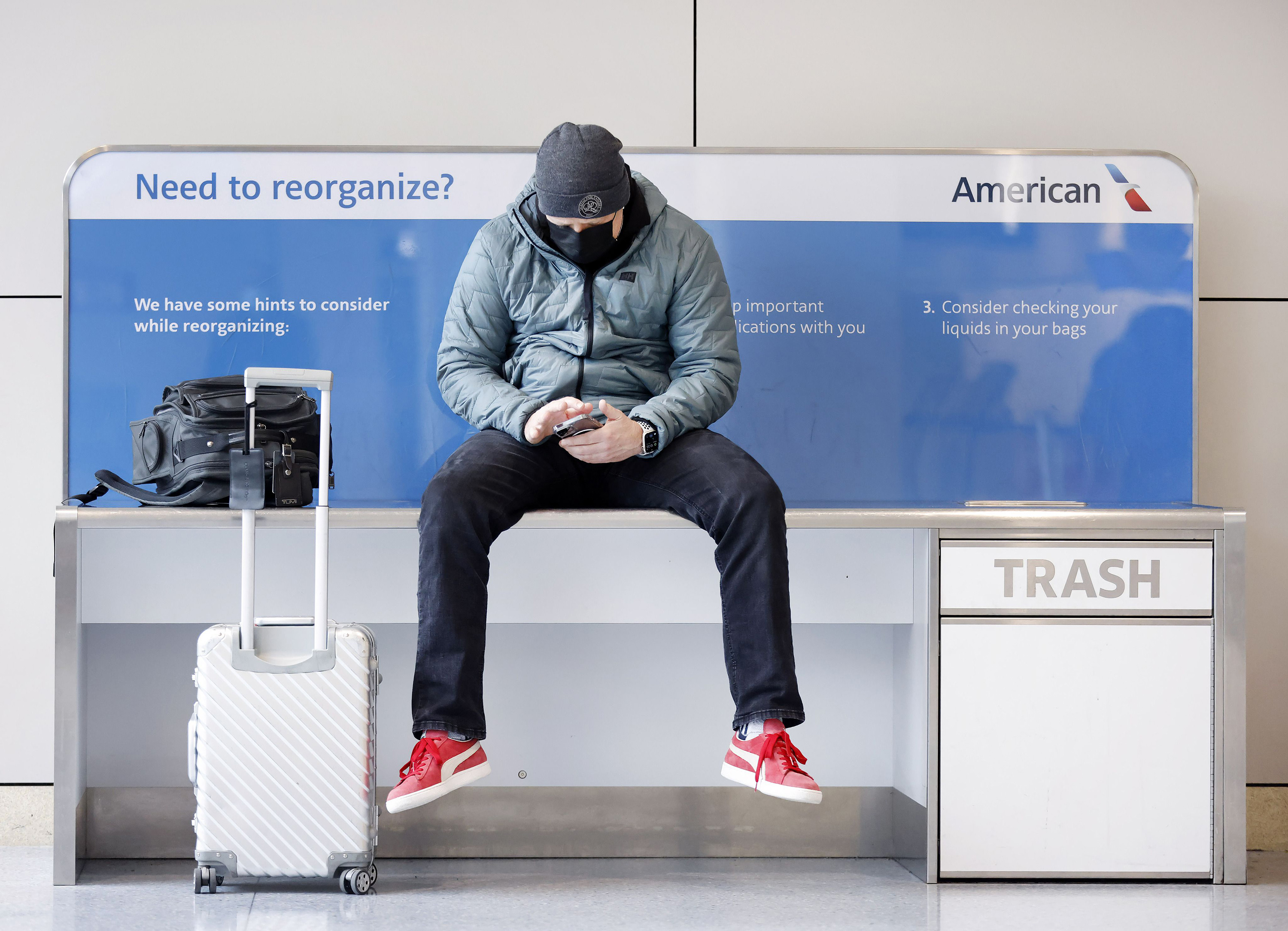 An American Airlines passenger listens to a conference call as he waits for his flight in Terminal A at DFW Airport on Feb. 23, 2022, in Dallas. (Tom Fox/The Dallas Morning News/TNS)