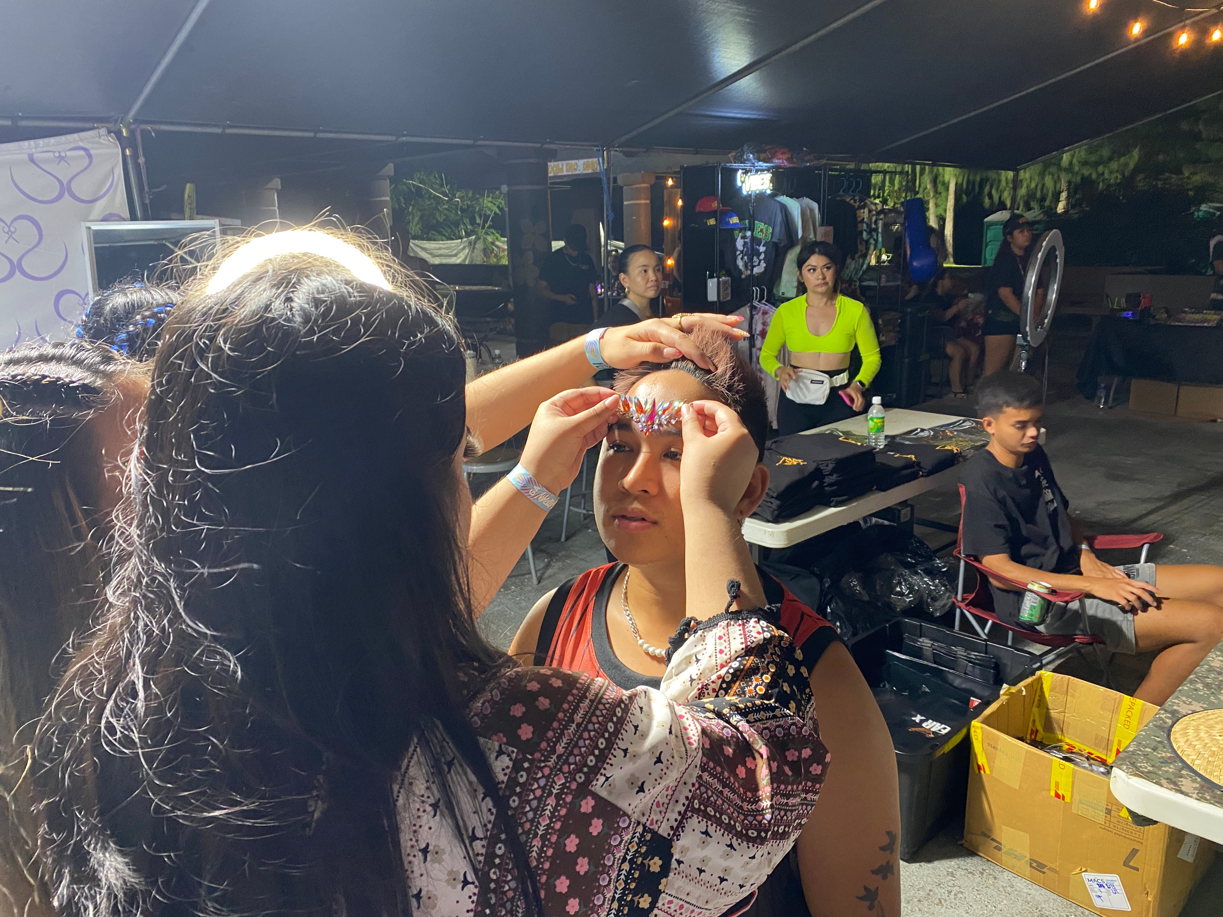 Body jewelry is applied on site at EIF Festival Saipan