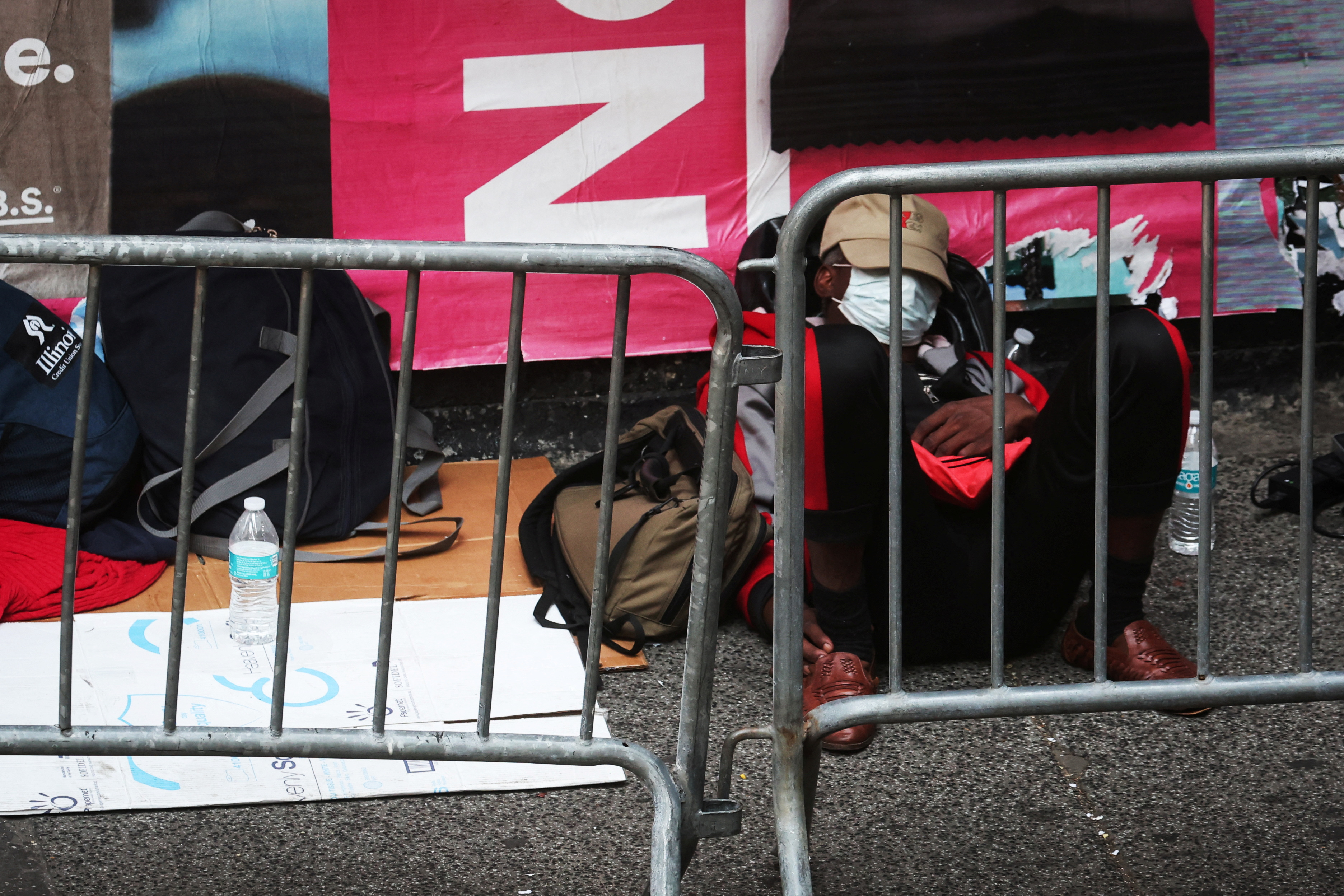 A recently arrived migrant New York City rests on the sidewalk outside the Roosevelt Hotel in midtown, Manhattan, where a temporary reception center has been established in New York City, New York, U.S., August 1, 2023. REUTERS/Mike Segar