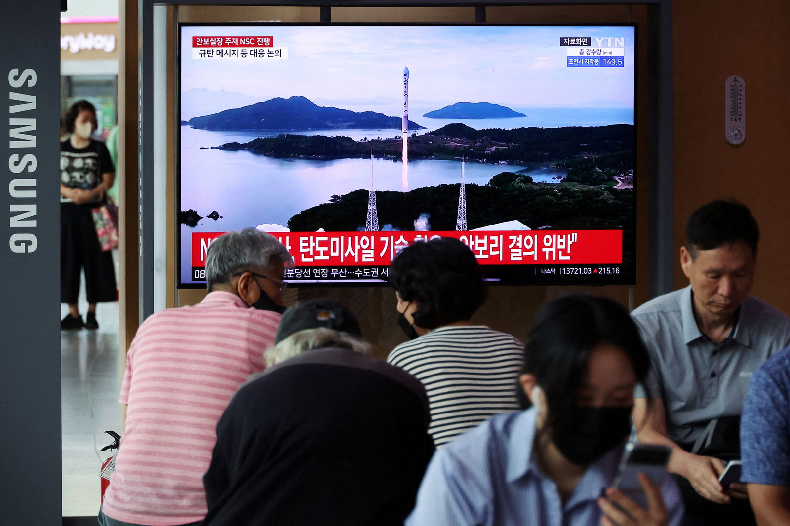 Passengers watch a TV broadcasting a news report on North Korea firing a space rocket, at a railway station in Seoul, South Korea, August 24, 2023. REUTERS/Kim Hong-Ji