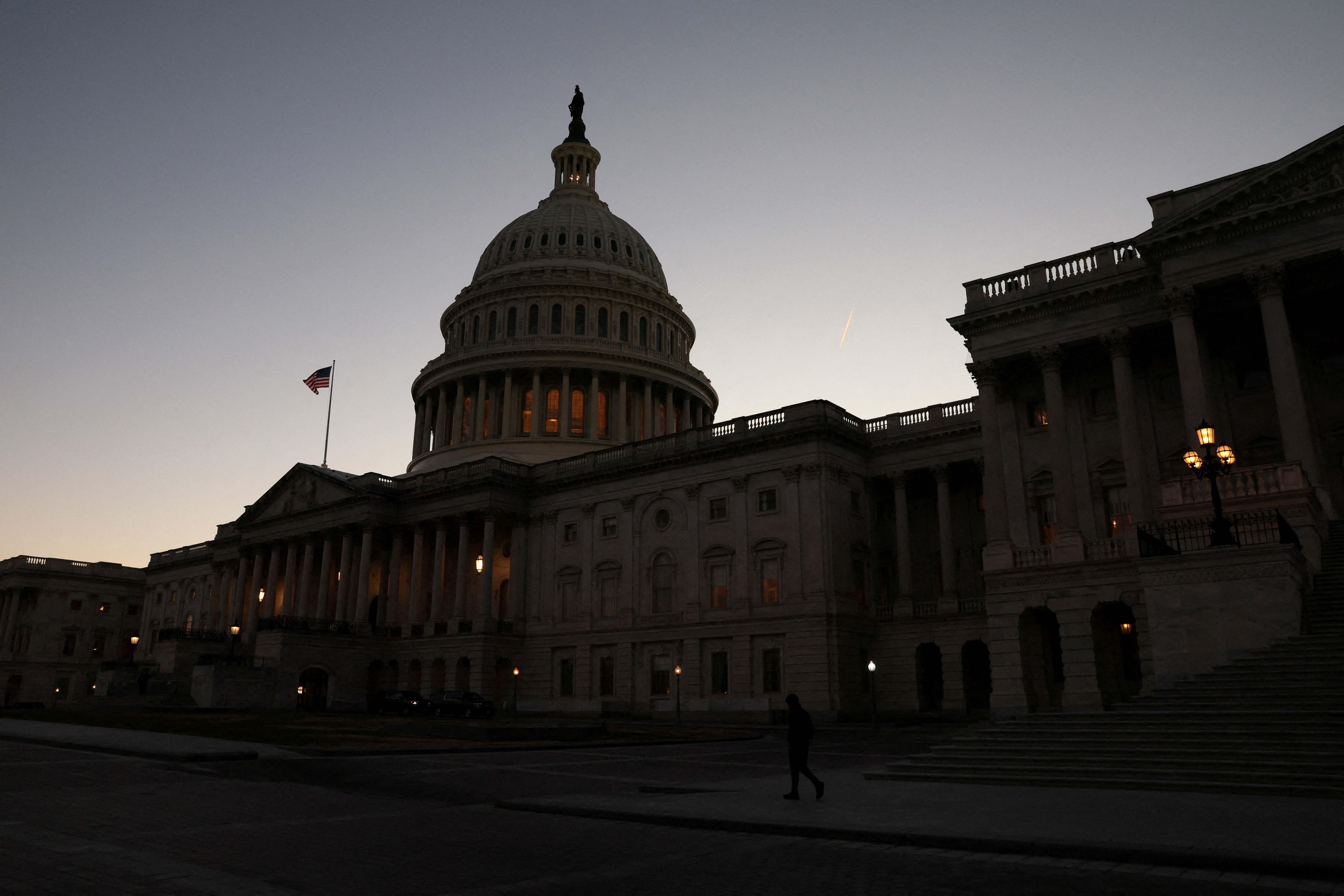A person walks past the U.S. Capitol building at sunset as the Republican-controlled House of Representatives reconvenes on Capitol Hill in Washington, U.S., January 9, 2023. REUTERS/Leah Millis/File Photo