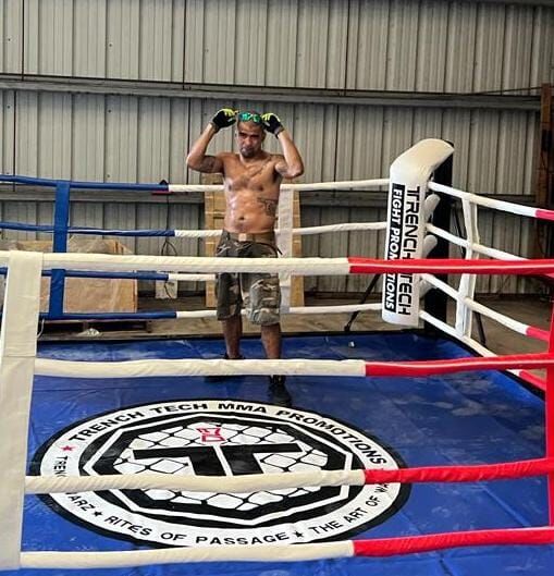 Cuki Alvarez poses for a photo after setting up a new boxing ring for the "Ring of Fire" boxing/kickboxing event slated for the end of the year.