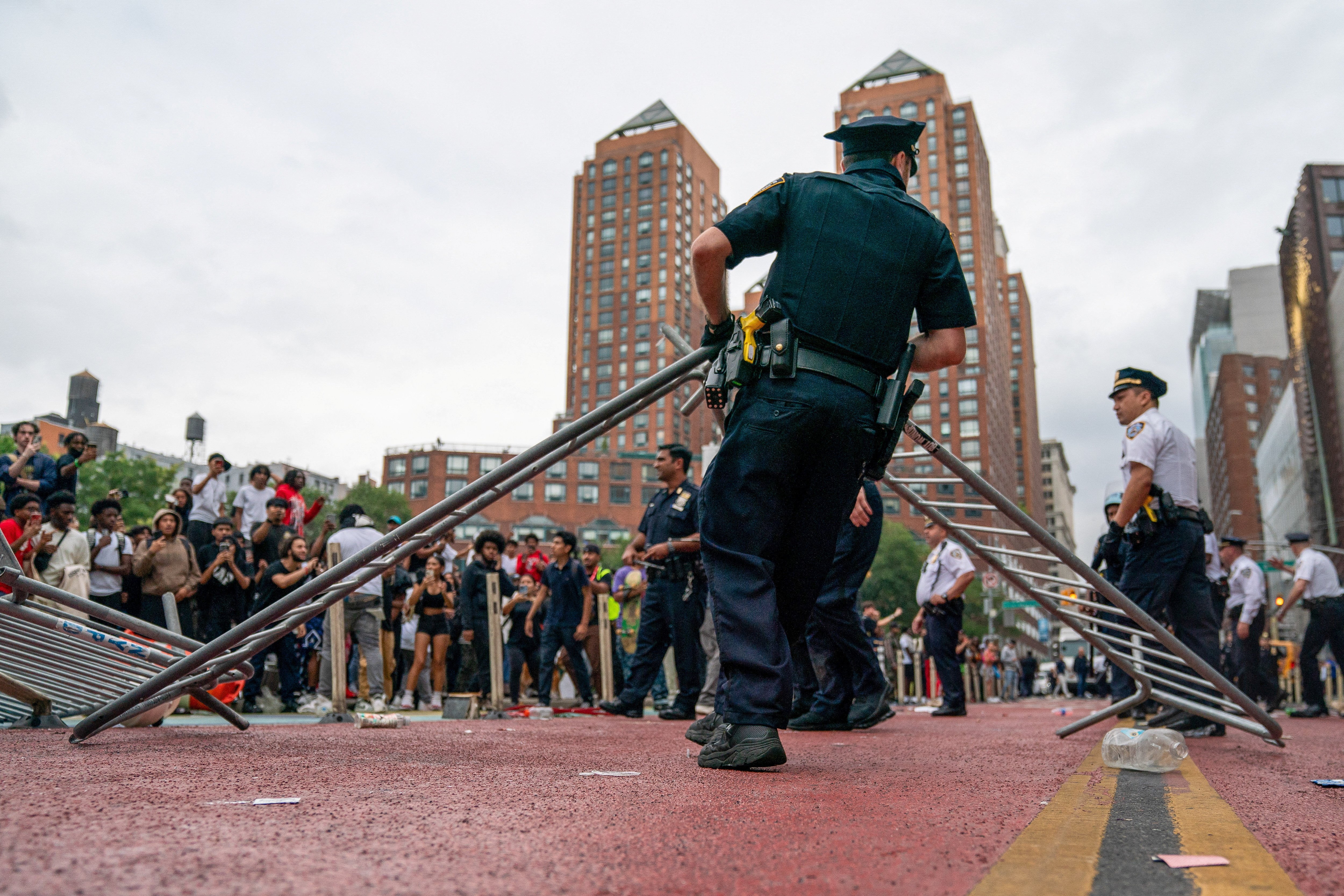 A police officer carries a barricade as other officers respond to a "giveaway" event announced by popular live streamer Kai Cenat that grew chaotic at Union Square and the surrounding streets in New York City, U.S. August 4, 2023. REUTERS/David 'Dee' Delgado