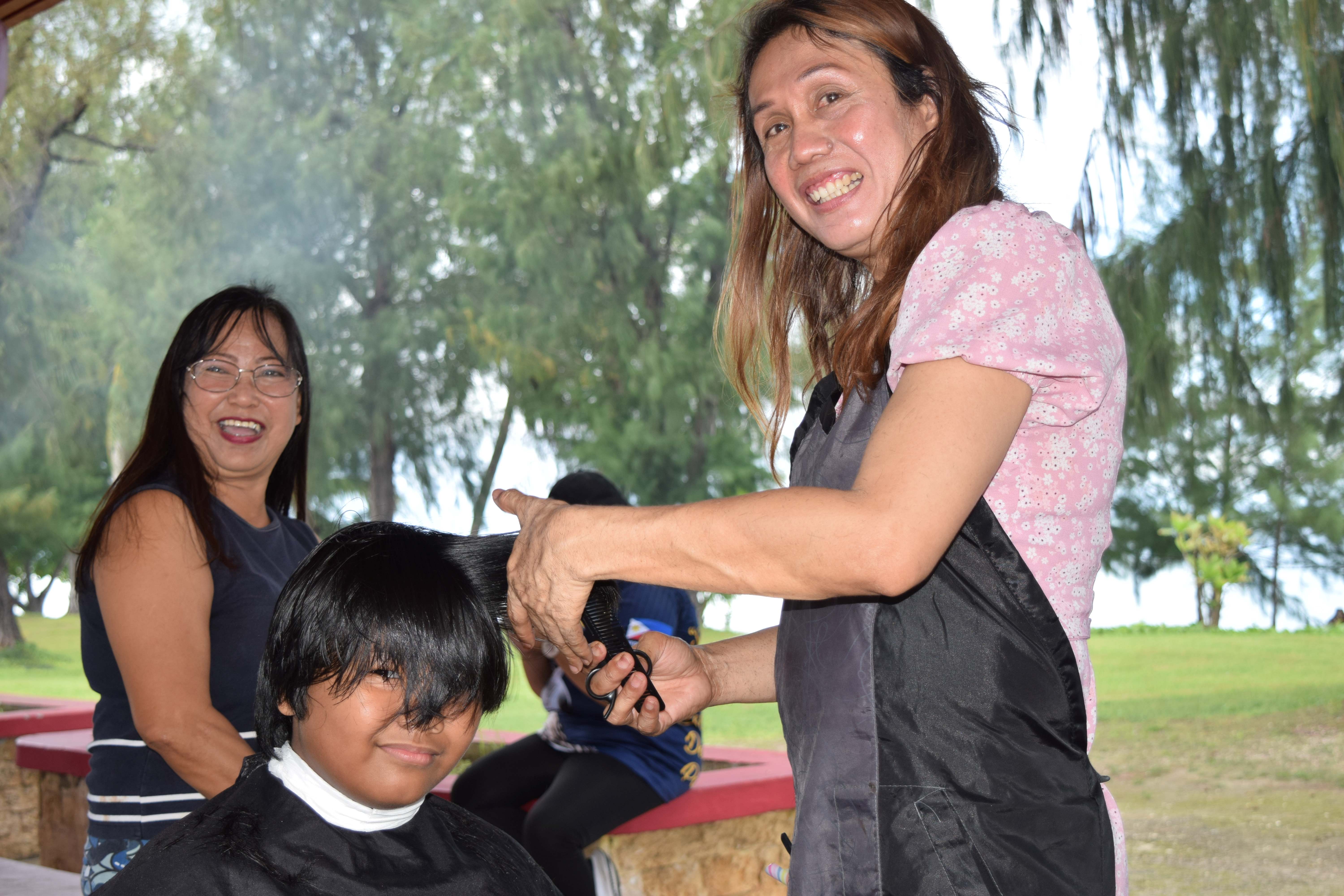 MommyLa Beauty Salon's Sharmaine Casquero gives a boy a haircut during the Saipan Magahaga Lady Eagles Group's Back-to-School Free Haircut event at the Minatchom Atdao Pavilion in Susupe on Sunday.