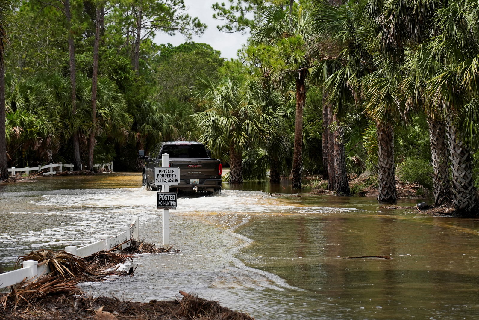 A vehicle drives on a flooded road after the arrival of Hurricane Idalia, in Cedar Key, Florida, U.S., August 30, 2023. REUTERS/Julio Cesar Chavez
