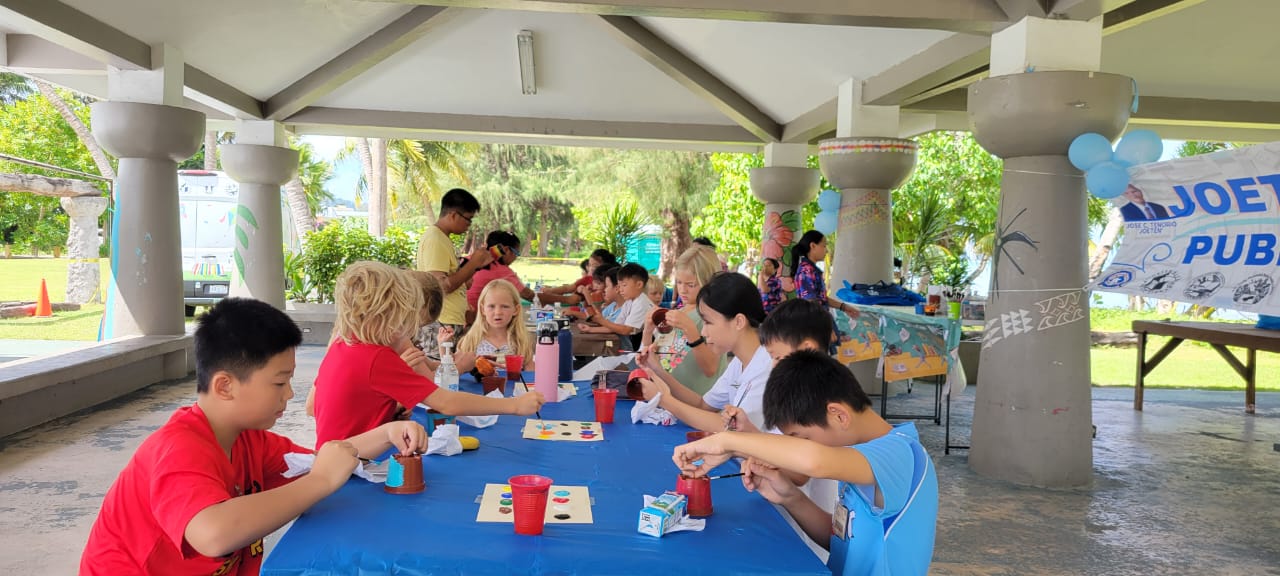 Students participating in the Bookmobile Outreach Service Summer Reading Program take part in a painting activity.