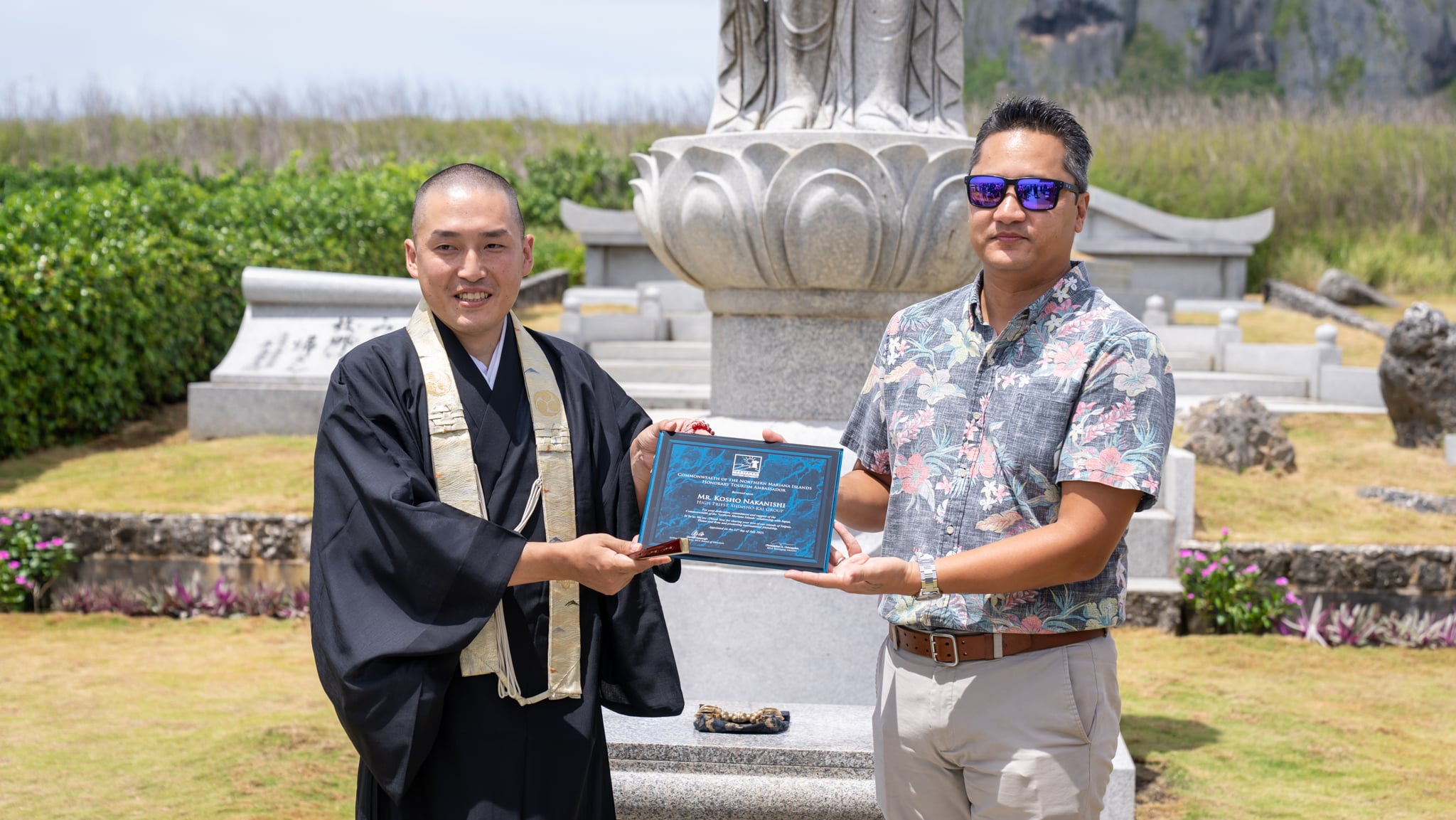 Shinsho-kai High Priest Kosho Nakanishi, left, is appointed Marianas tourism ambassador on July 22, 2023, by Marianas Visitors Authority Managing Director Christopher A. Concepcion at Banzai Cliff, Saipan.  Shinsho-kai has been making semi-annual memorial pilgrimages to Saipan since 1982 in memory of Japanese citizens who lost their lives on the island during World War II.