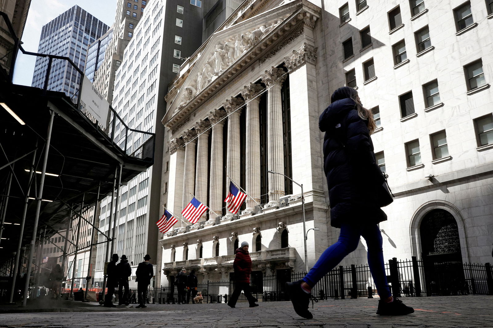 People are seen on Wall Street outside the New York Stock Exchange (NYSE) in New York City, U.S., March 19, 2021. REUTERS/Brendan McDermid/File Photo