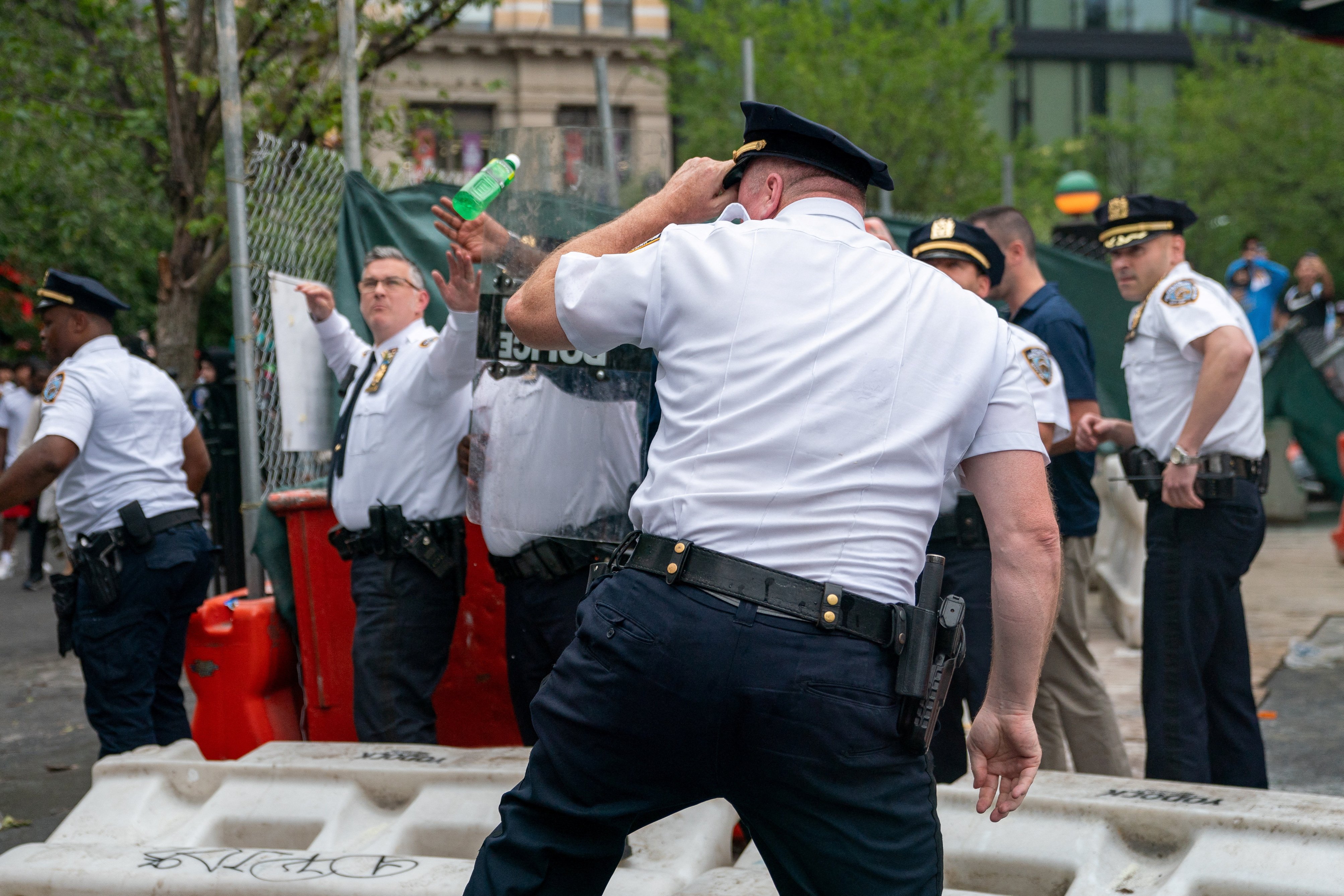Police officers take cover from objects thrown by people as they respond to a "giveaway" event announced by popular live streamer Kai Cenat that grew chaotic at Union Square and the surrounding streets in New York City, U.S. August 4, 2023. REUTERS/David 'Dee' Delgado