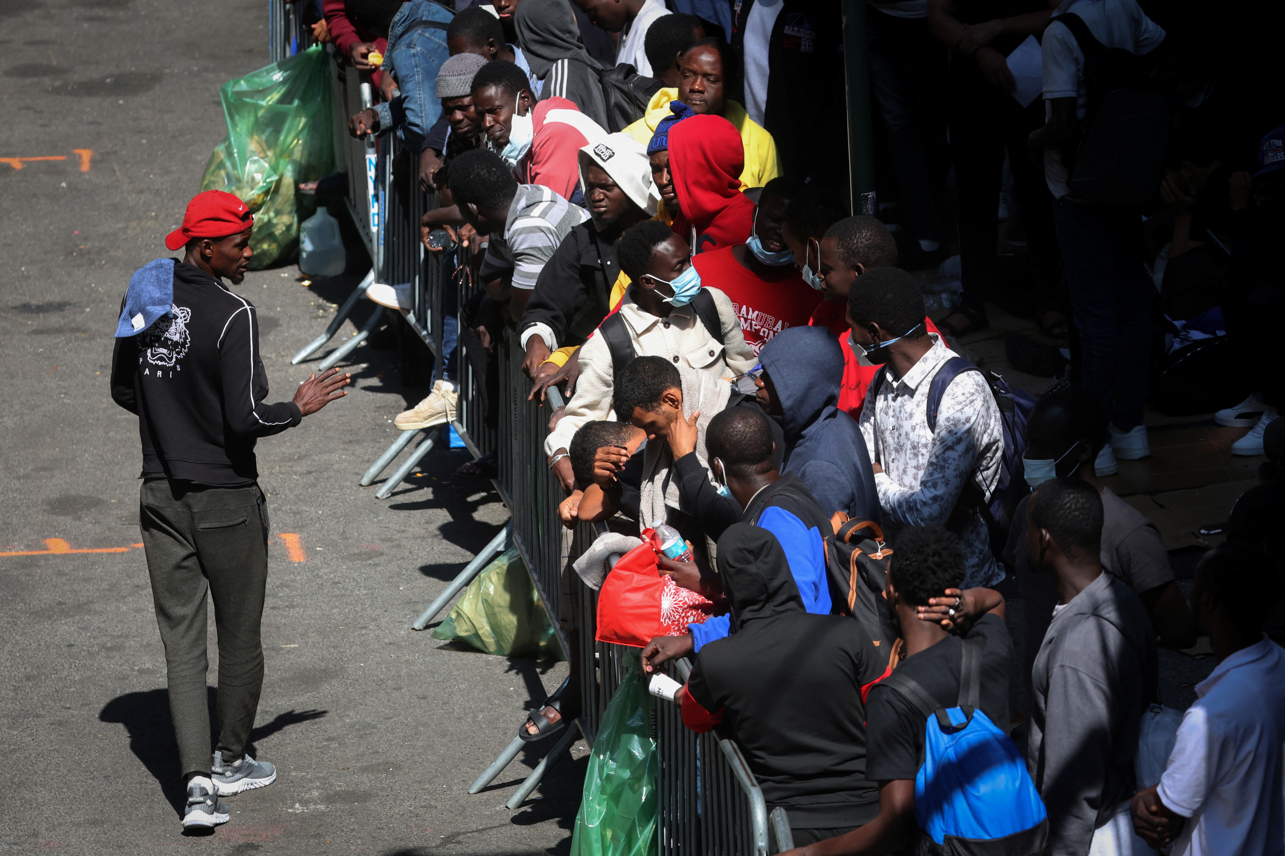 Recently arrived migrants to New York City wait on the sidewalk outside the Roosevelt Hotel in midtown, Manhattan, where a temporary reception center has been established in New York City, New York, U.S., August 1, 2023. REUTERS/Mike Segar