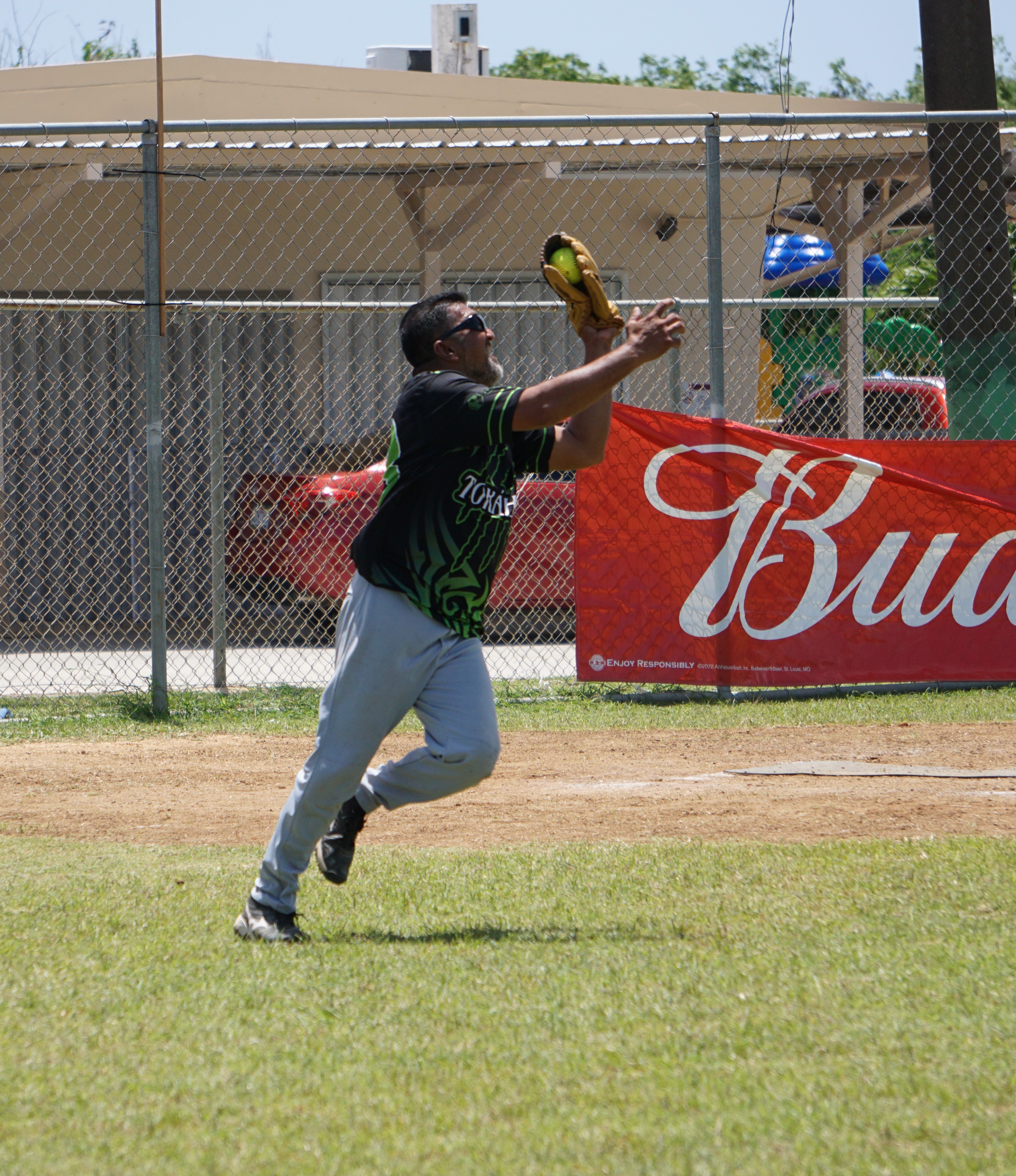 Payday Hao catcher Manny Villagomez catches a pop fly during an Open League game of the Budweiser Belau Amateur Softball Association at the Dandan baseball field.