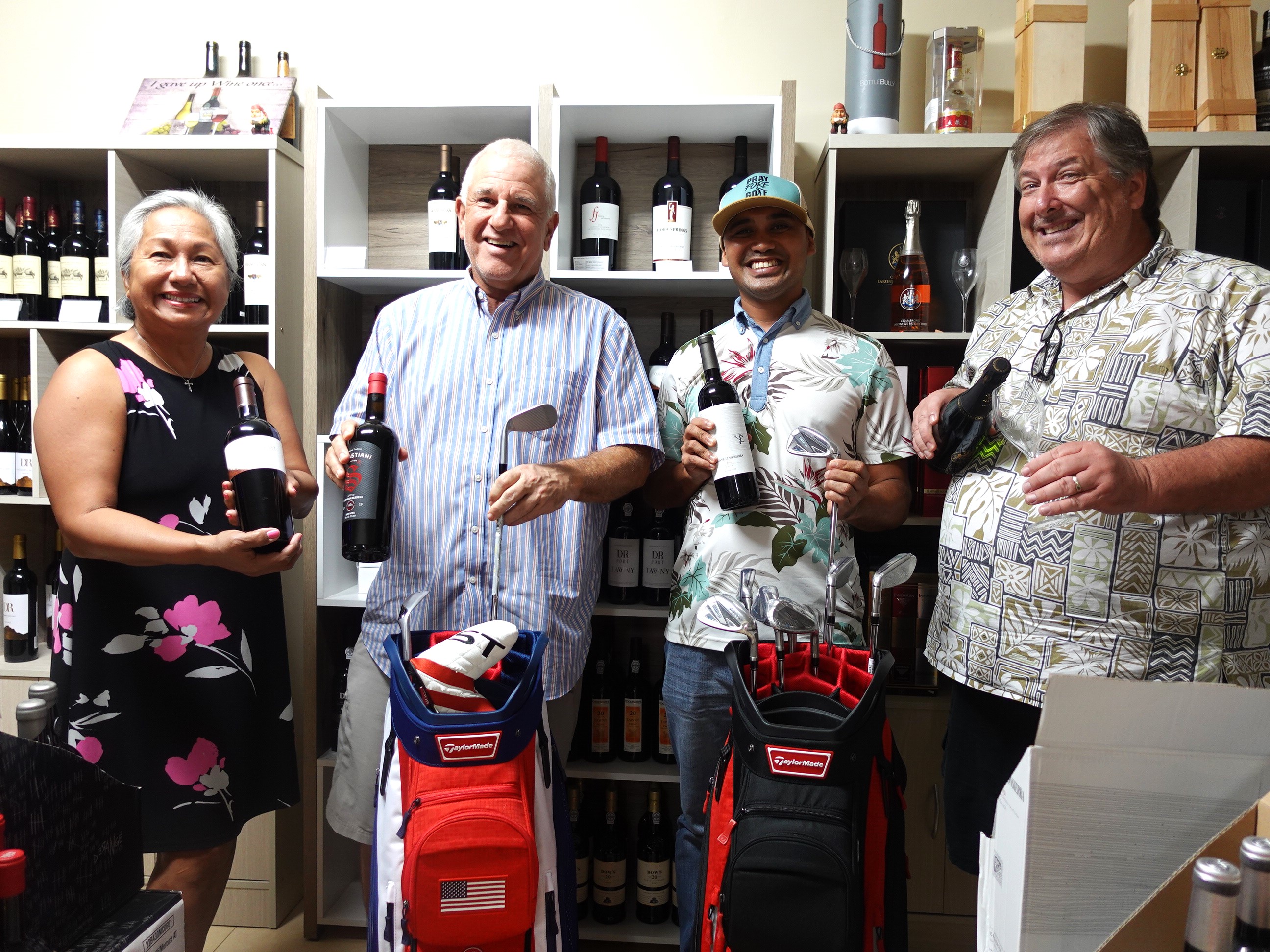 Top Shelf Wines & Spirits General Manager John Jones, second left, presents a selection of wine and a $10,000 in-kind hole-in-one prize on Aug. 11, 2023, in Gualo Rai, Saipan, for the Marianas Tourism Golf Classic to be held on Sept. 2, 2023, at LaoLao Bay Golf & Resort.  Proceeds of the tournament will benefit Marianas Tourism Education Council and school MY WAVE (Marianas Youth Welcome All Visitors Enthusiastically) clubs.   From left, MTEC Chairwoman Vicky Benavente, Jones, former MY WAVE club member and tournament committee member Franco Santos, and tournament committee vice chairman Glenn Policare.