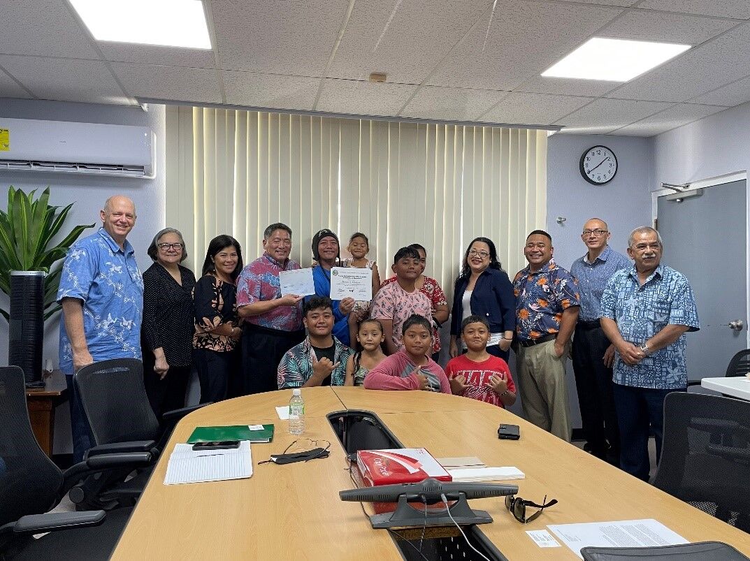 Family Self-Sufficiency  Program graduate Michael Q. Tomokane and family with U.S. Department of Housing & Urban Development  representatives, Northern Marianas Housing Corporation  board of directors, corporate director and deputy corporate director.