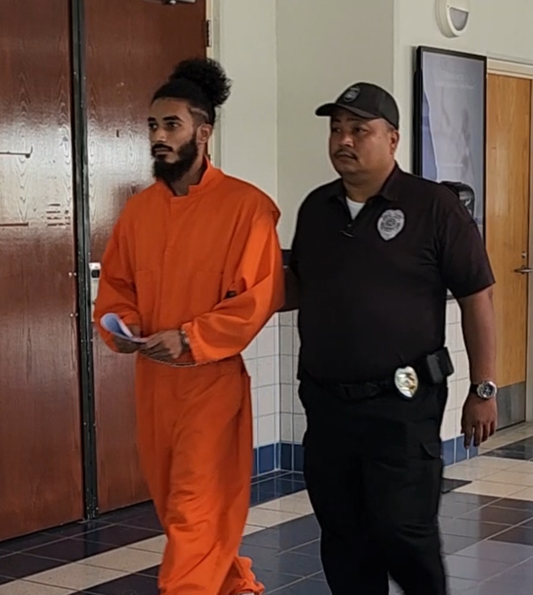 Khandakar S. Rahaman is escorted by a Corrections officer to a bail hearing at the judicial building Friday.