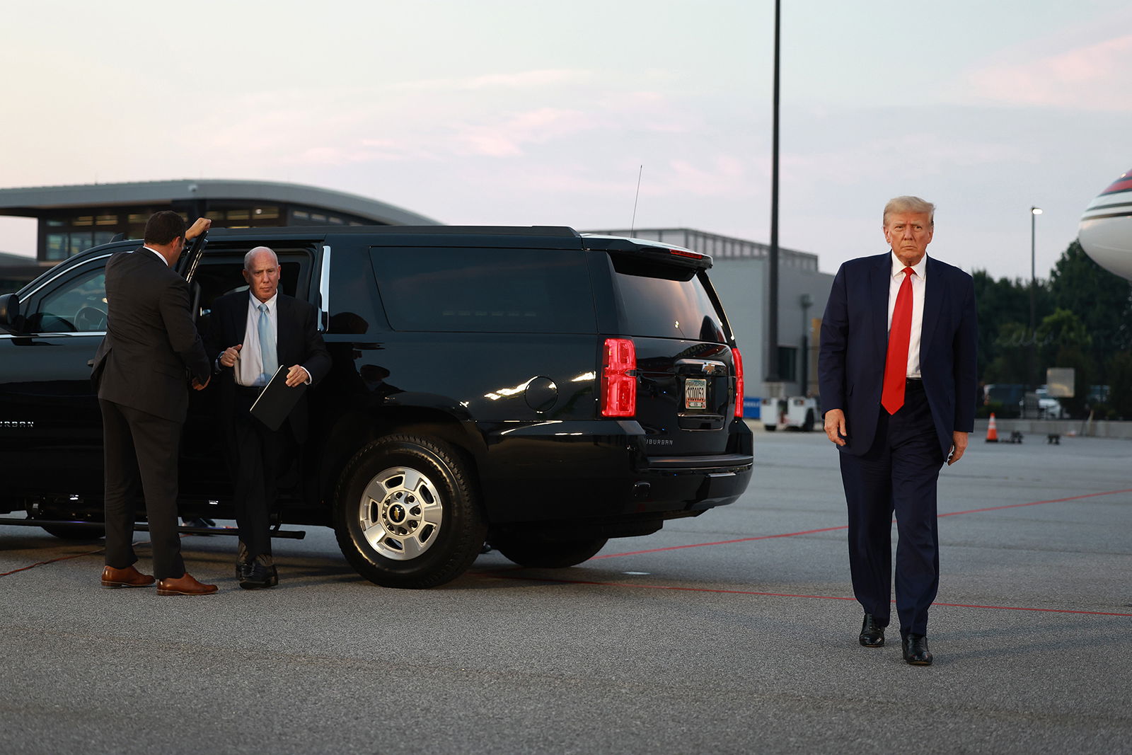 Former U.S. President Donald Trump and his lawyer, Steven Sadow (left), arrive at Atlanta Hartsfield-Jackson International Airport after being booked at the Fulton County jail on Aug. 24, 2023, in Atlanta, Georgia. Trump surrendered to multiple charges related to an alleged plan to overturn the results of the 2020 presidential election in Georgia. (Joe Raedle/Getty Images/TNS)