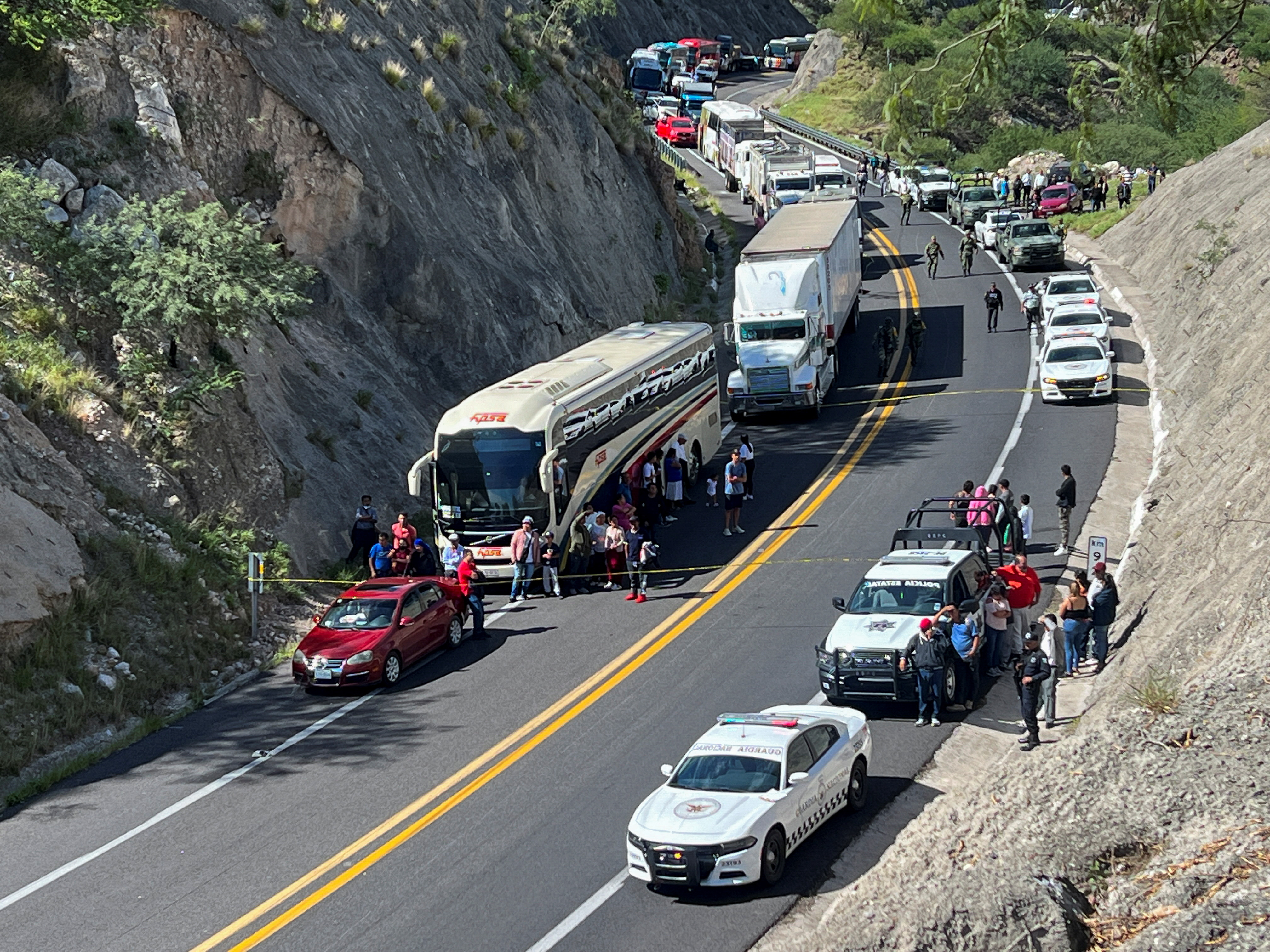 Stranded vehicles are seen as authorities work at the area of a road accident, which left over a dozen migrants dead, in Tepelmeme Villa de Morelos, in Oaxaca state, Mexico August 22, 2023. REUTERS/Jose de Jesus Cortes